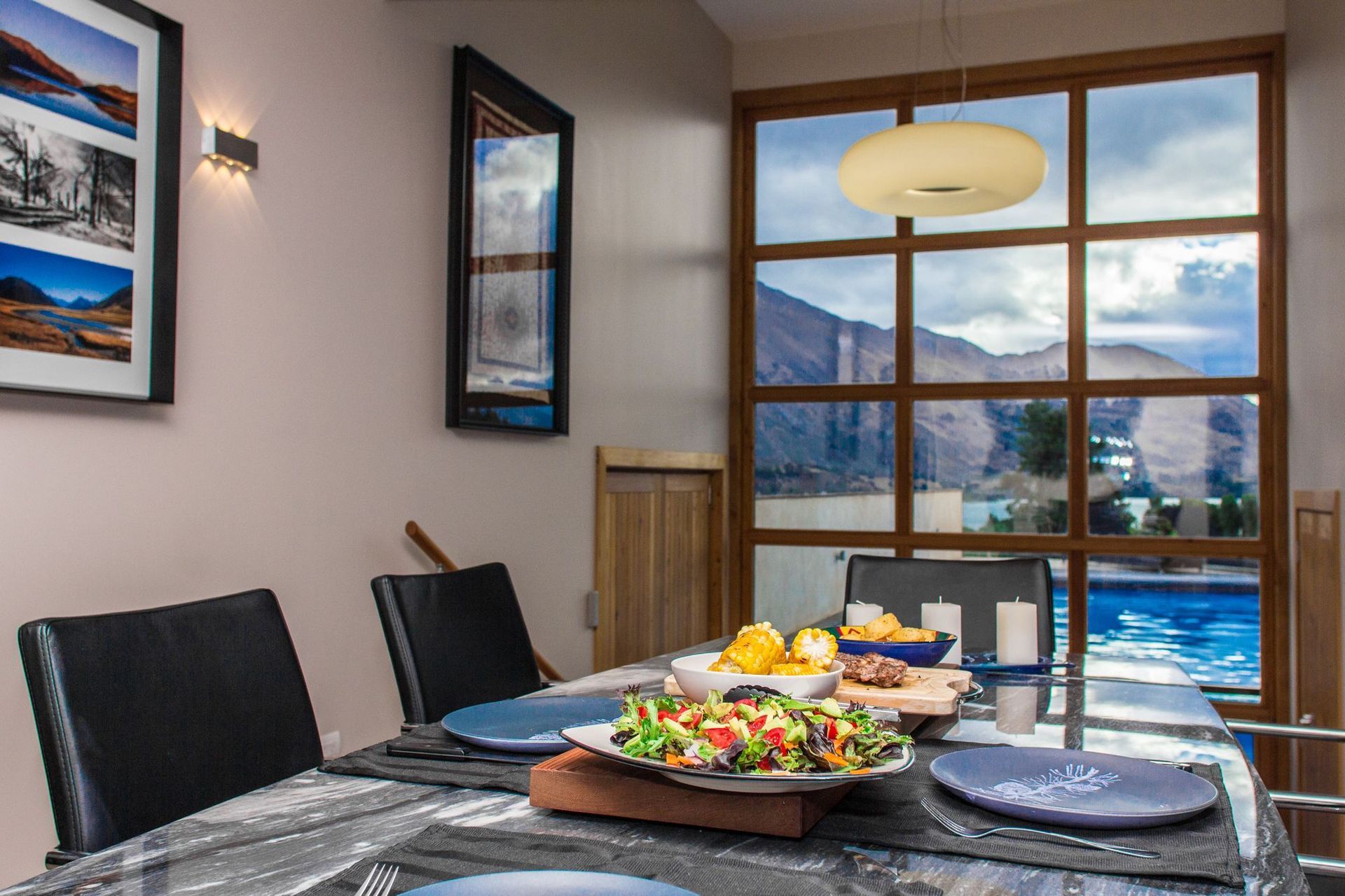 The view from the dining tbale is over the pool and Lake Wanaka to the mountains beyond.