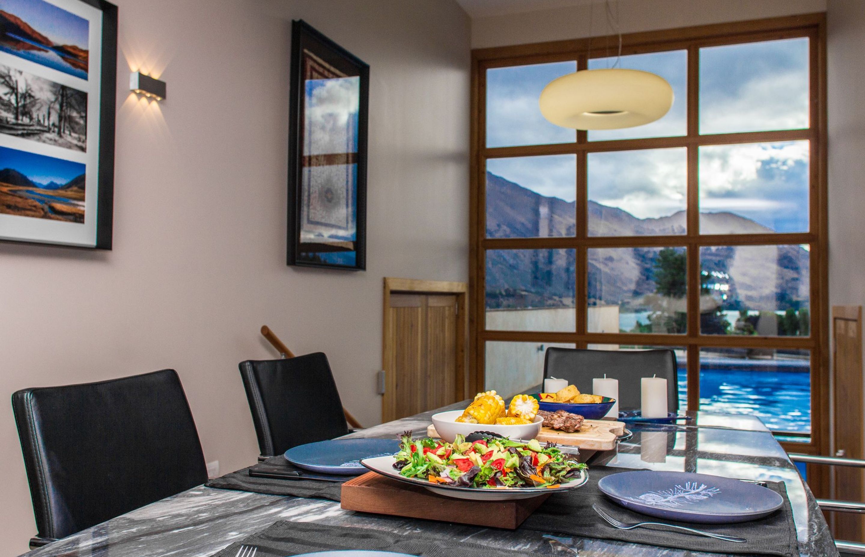 The view from the dining tbale is over the pool and Lake Wanaka to the mountains beyond.