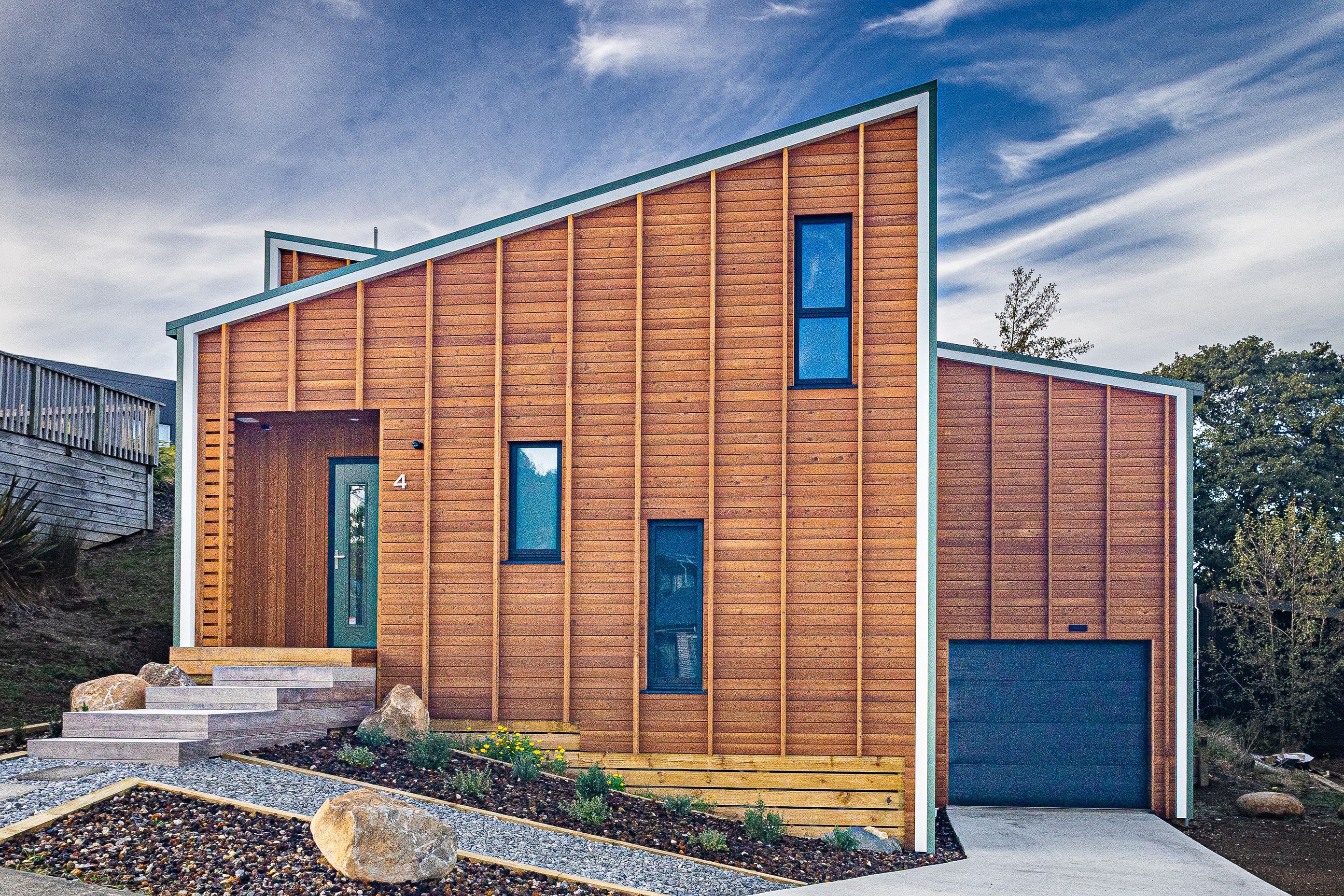 Vertical battens over larch weatherboards accentuate the height of the house.