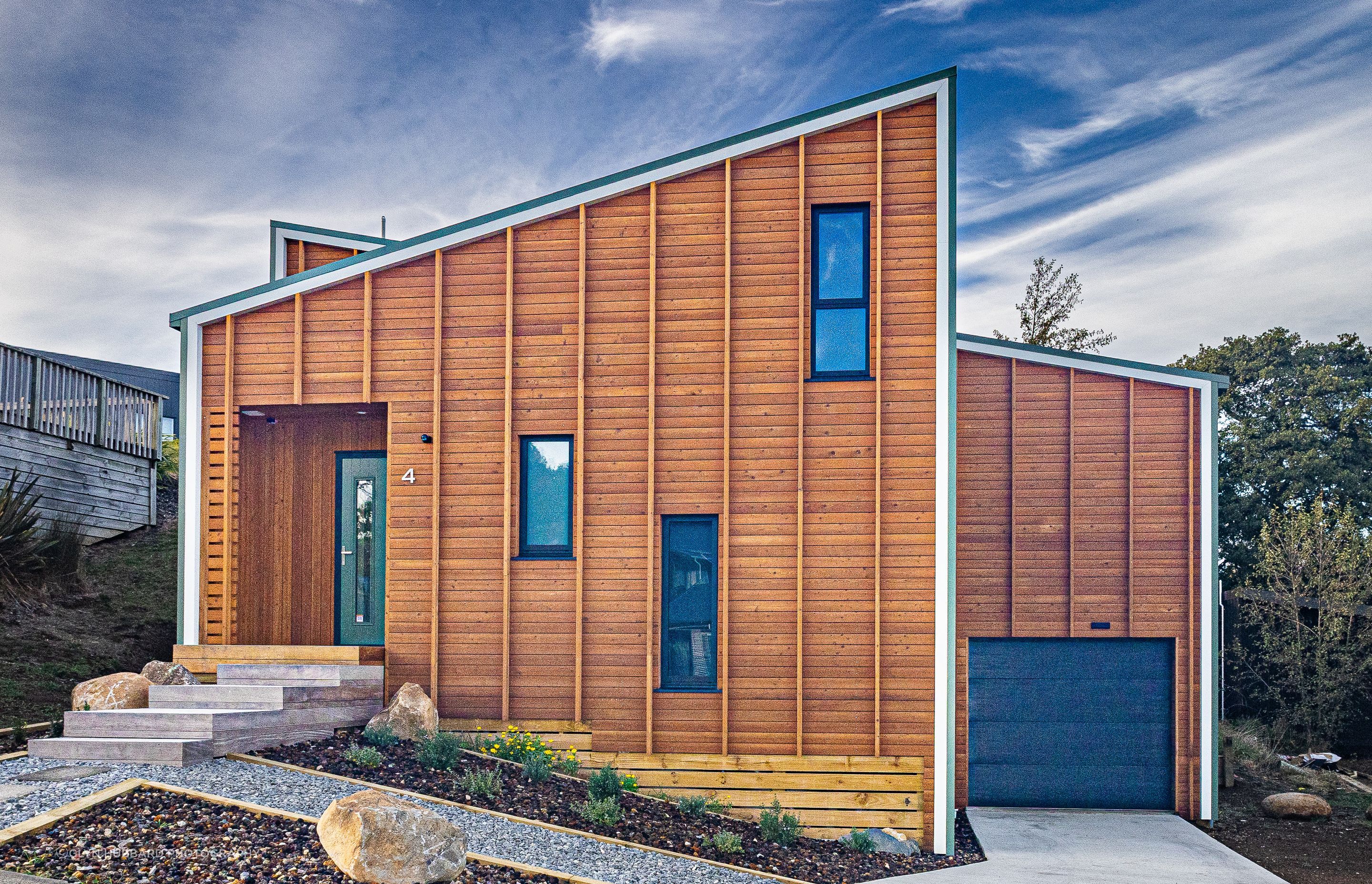 Vertical battens over larch weatherboards accentuate the height of the house.