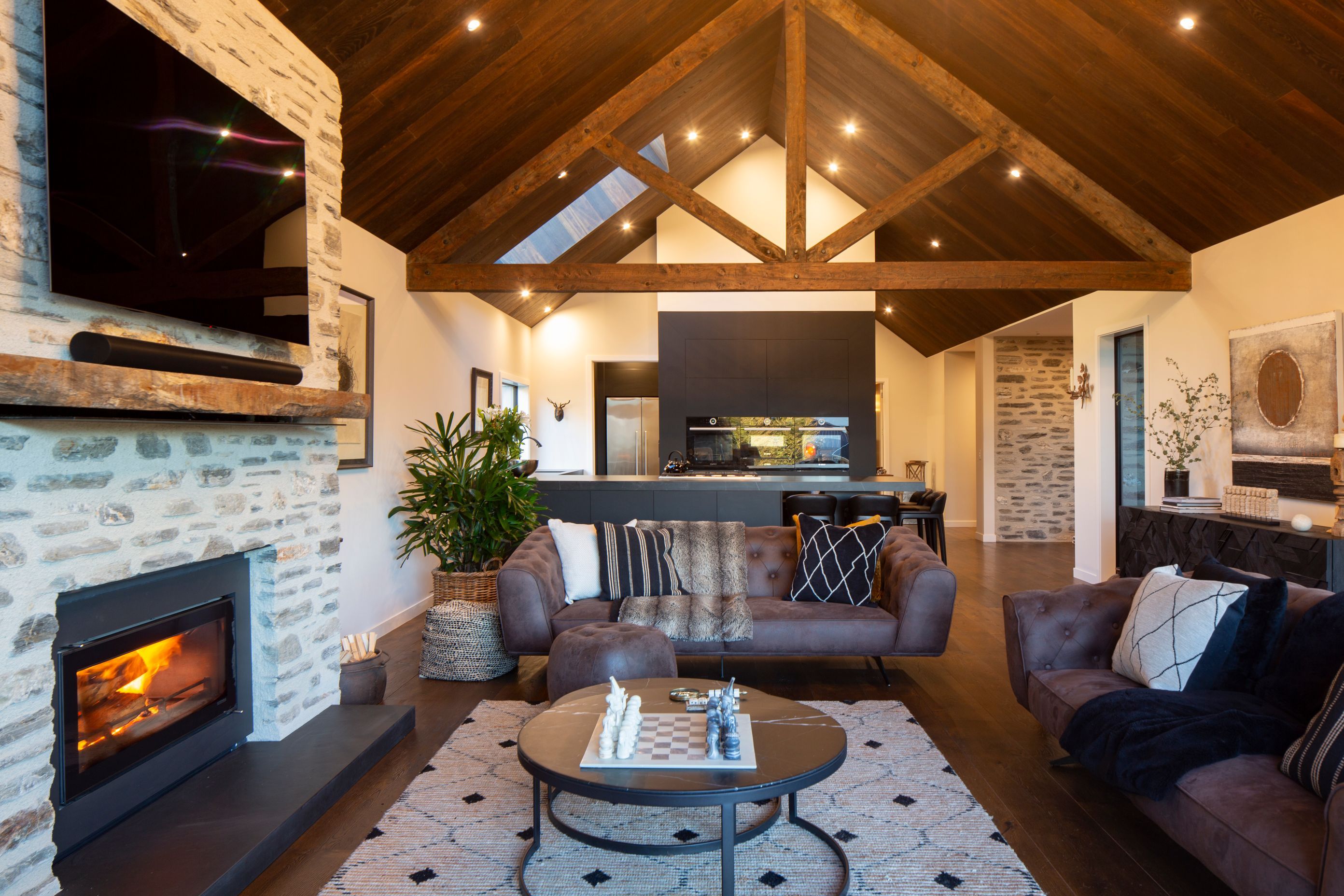 Exposed trusses, French oak flooring and a fireplace wrapped in long, thin schist sourced from Glenorchy give a lodge-like flavour to the interiors.