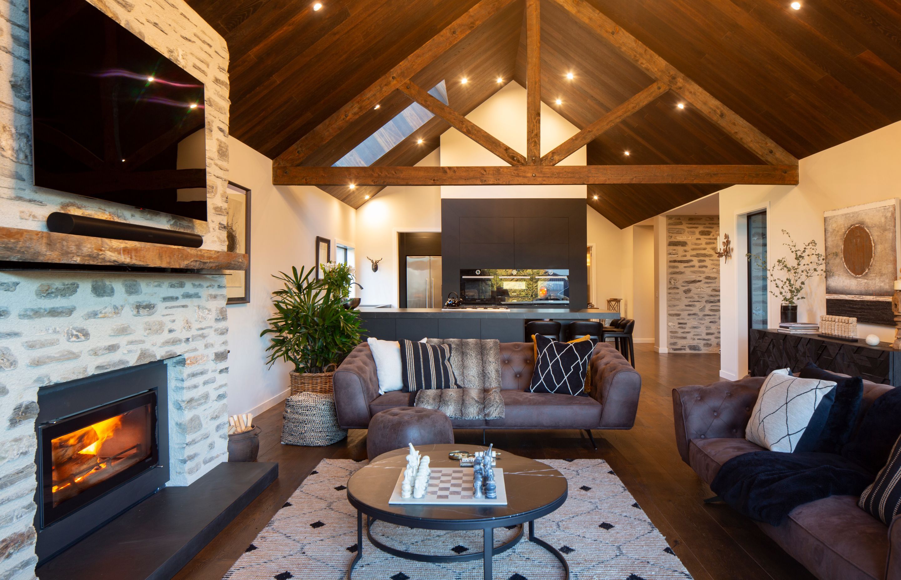 Exposed trusses, French oak flooring and a fireplace wrapped in long, thin schist sourced from Glenorchy give a lodge-like flavour to the interiors.