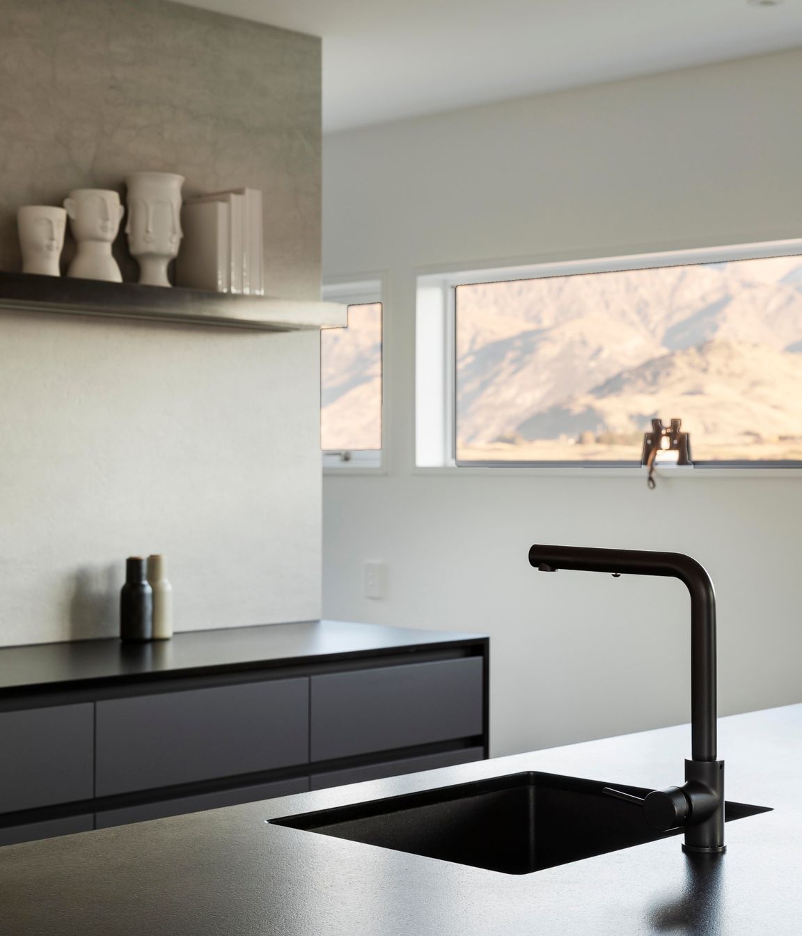 A slot window that runs along the kitchen wall at head height, captures The Remarkables perfectly.