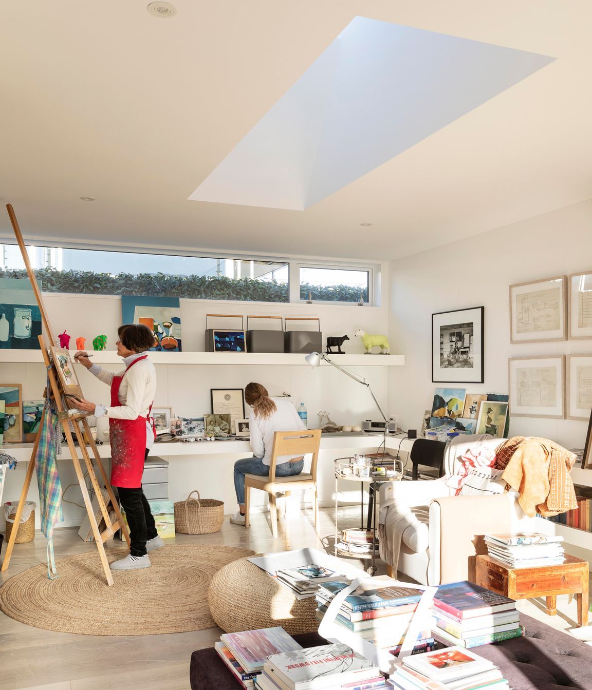 Jane painting in her studio, with her daughter working alongside.