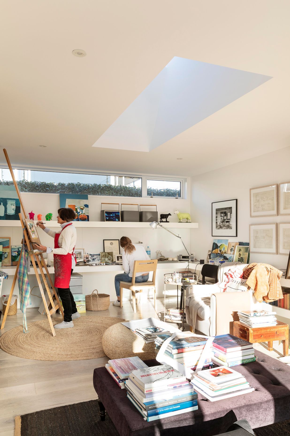 Jane painting in her studio, with her daughter working alongside.