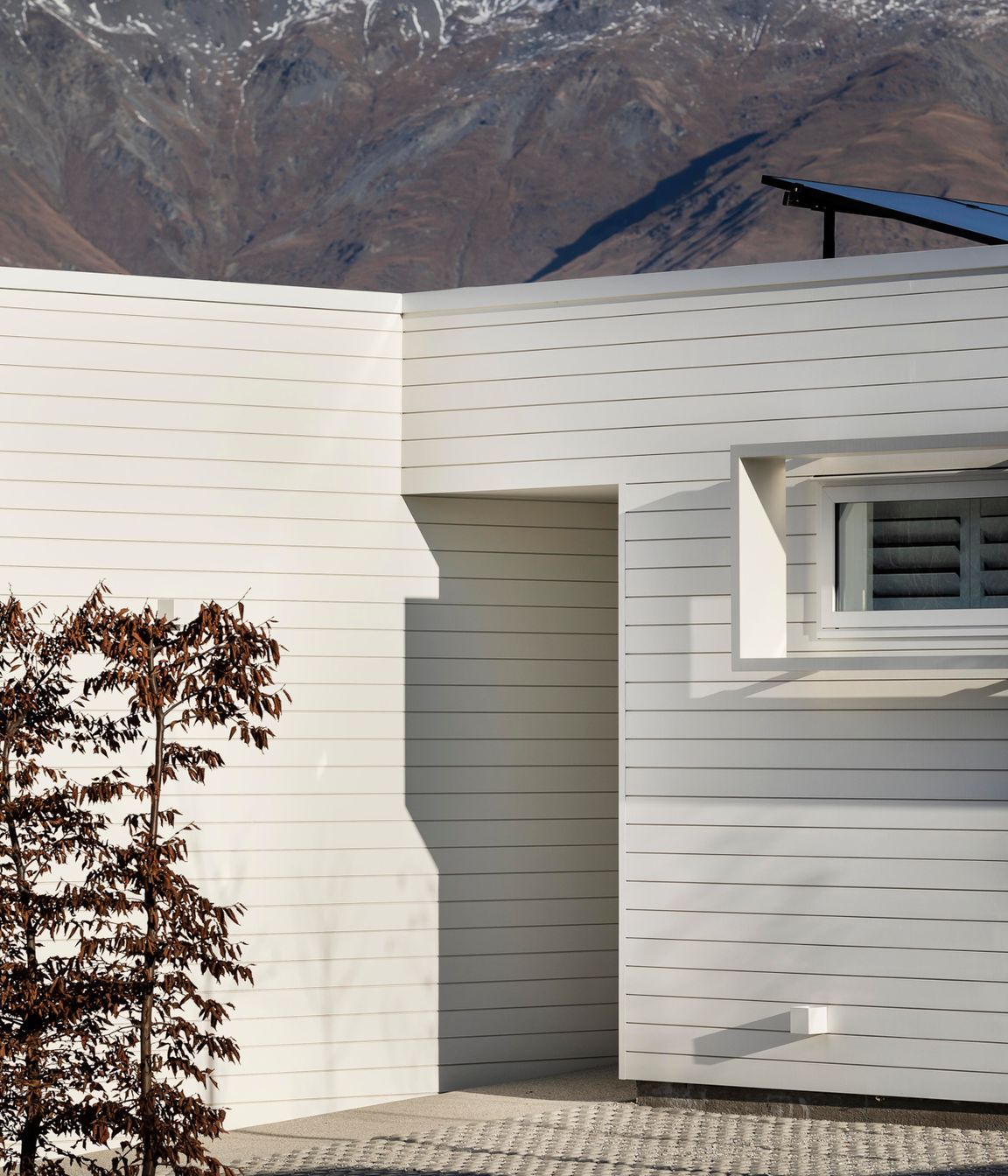 The entry is humble in scale and recessed into the house for privacy.