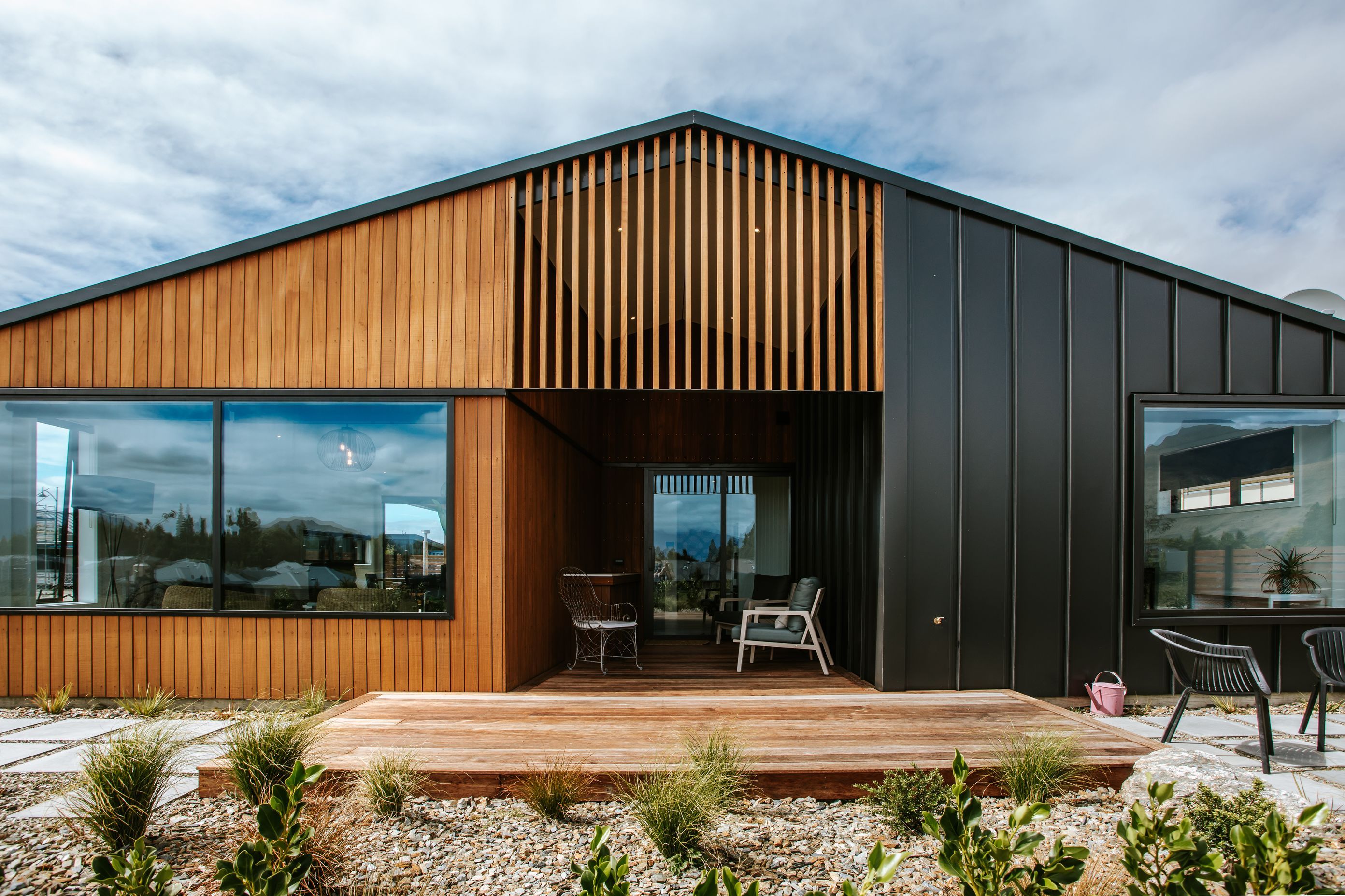 The back of the home juxtaposes dark tray cladding against warm timber cladding.