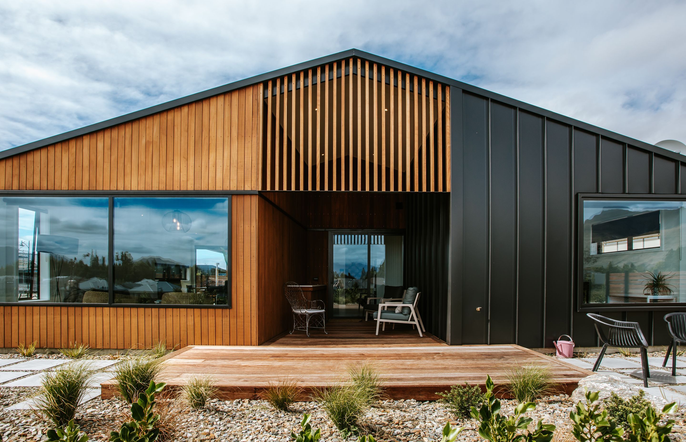 The back of the home juxtaposes dark tray cladding against warm timber cladding.