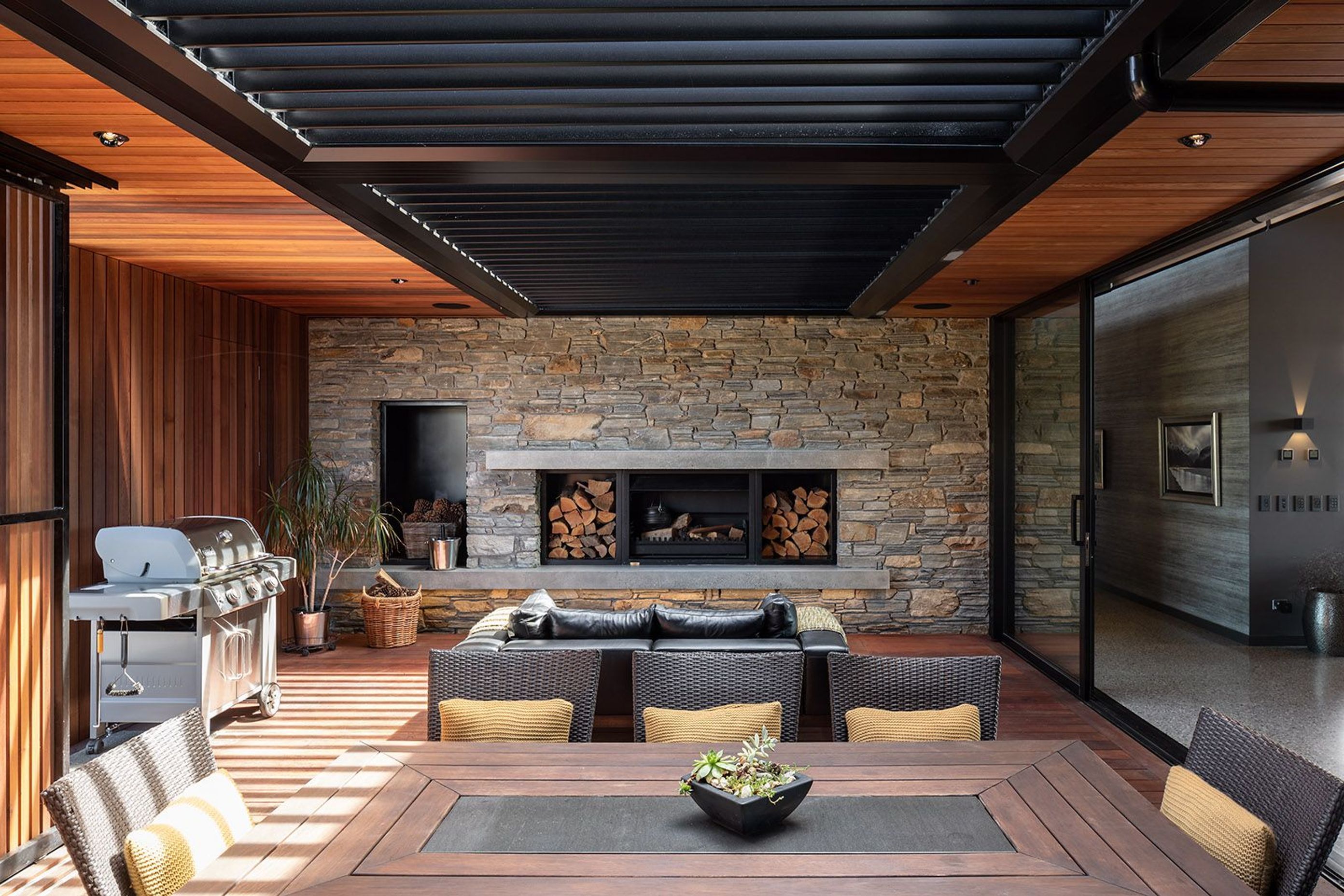 The courtyard at the back of the living spaces features moveable cedar screens that filter light into the cosy space.