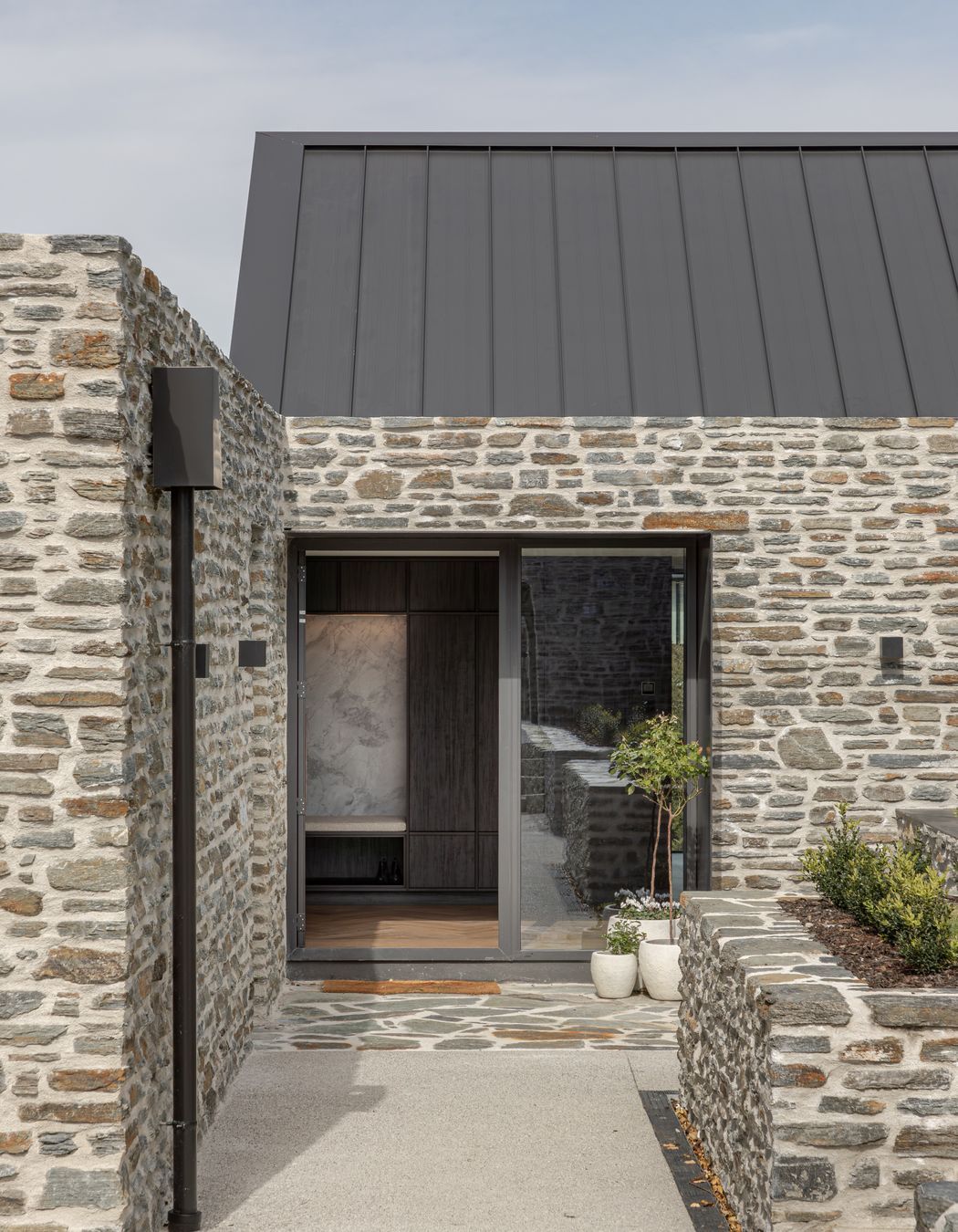 Schist stone cladding and paving defines the main entrance