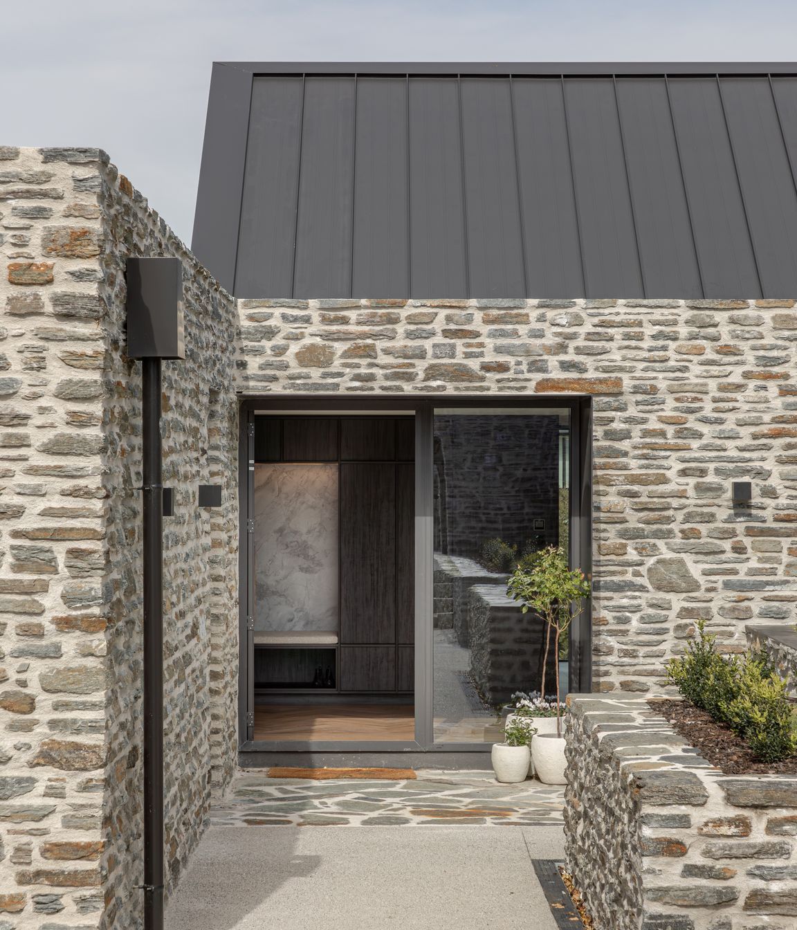 Schist stone cladding and paving defines the main entrance