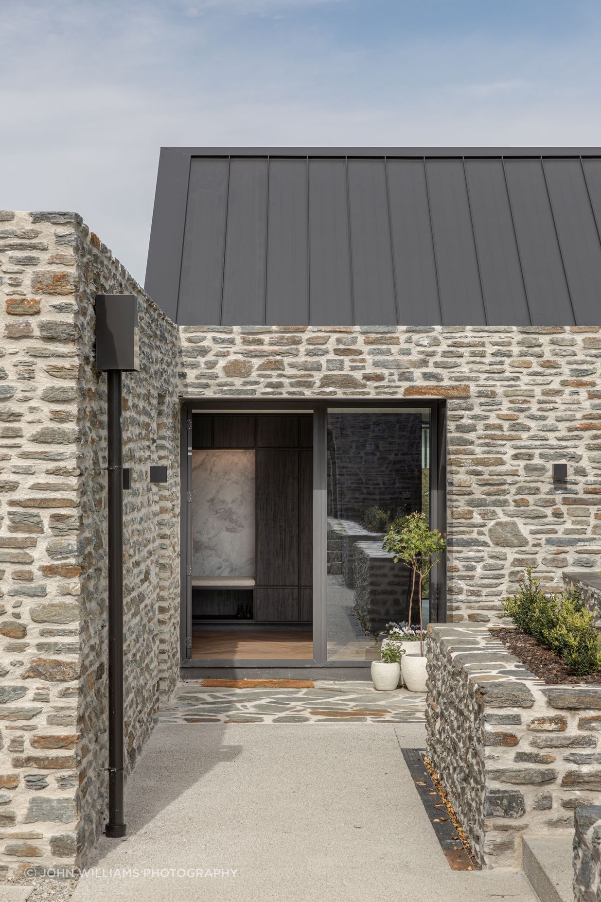 Schist stone cladding and paving defines the main entrance