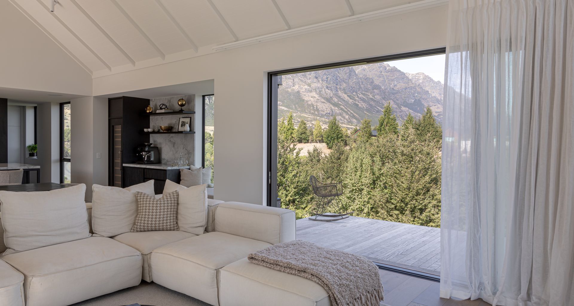 Living spaces flow to a cantilevered deck overlooking the Remarkables mountain range