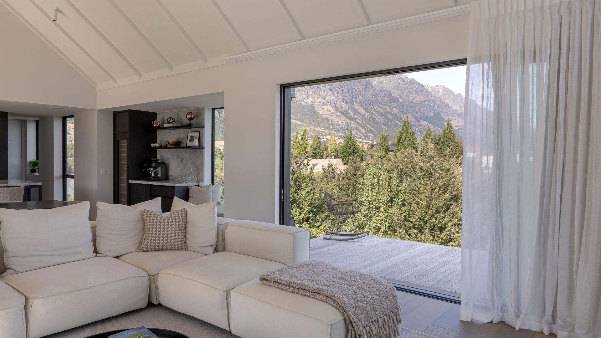 Living spaces flow to a cantilevered deck overlooking the Remarkables mountain range