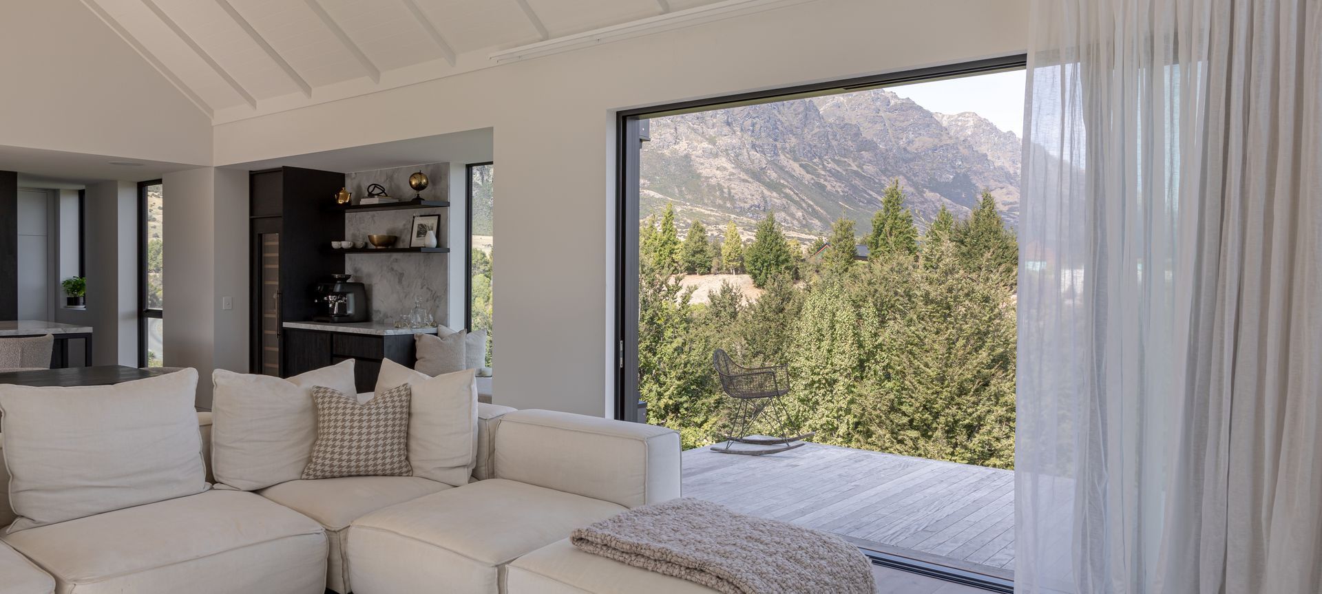 Living spaces flow to a cantilevered deck overlooking the Remarkables mountain range