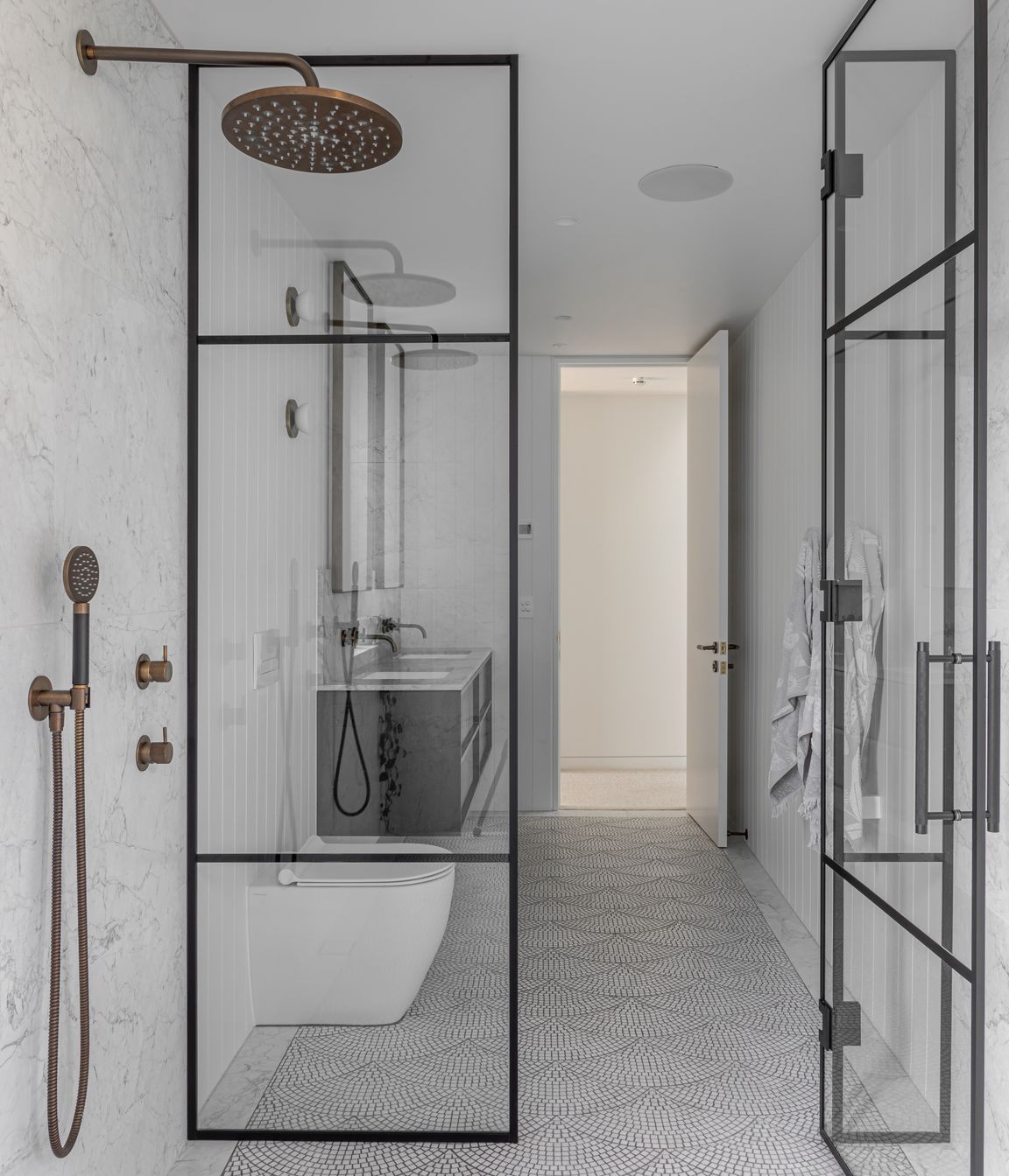 Generous airy bathrooms are tiled in a fan pattern with light marble mosaic