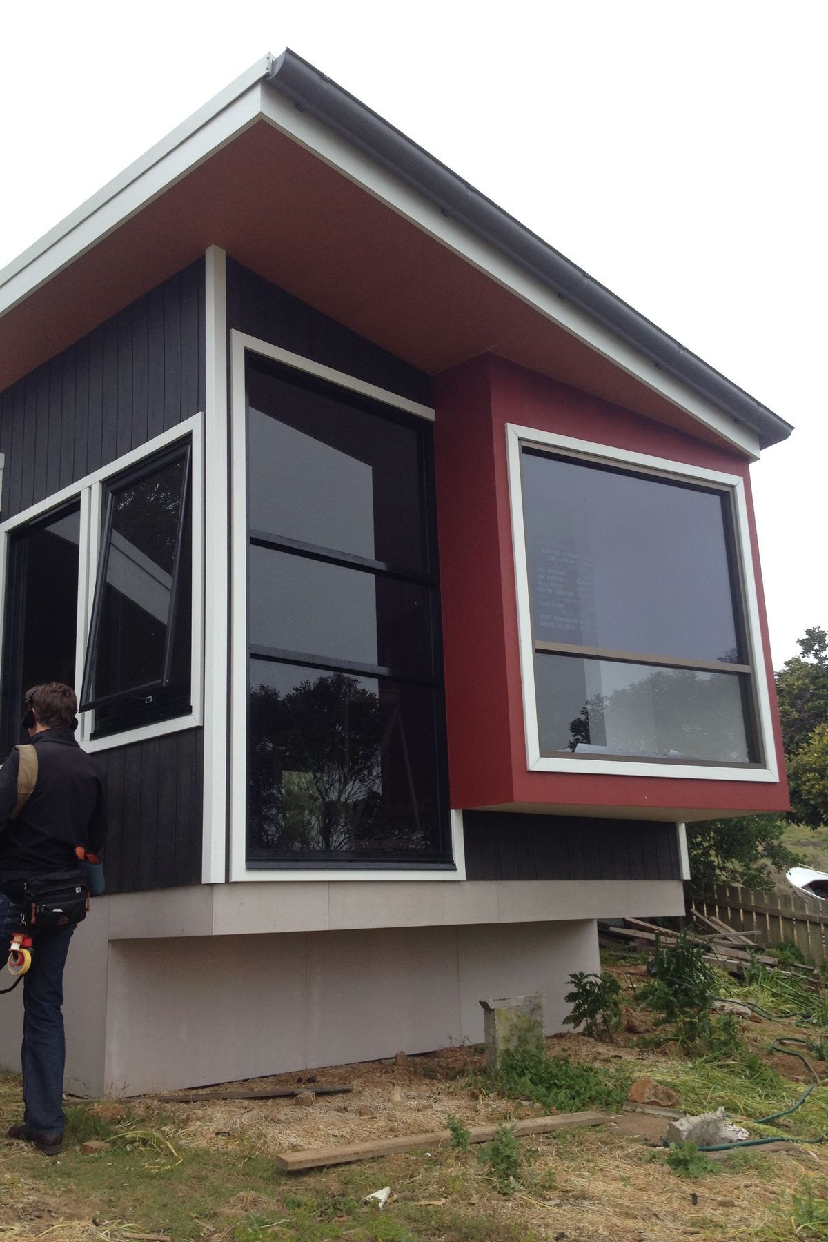 Materials are robust. Ecoply shadow clad v-joint board, with harries vero board (floor had to be enclosed for BAL requirements). Builder put the gutter on the front of the cottage, without instruction, between site visits. Colours are taken from the landscape-charcoal of the basalt of The Nut, red for the iron rich soil