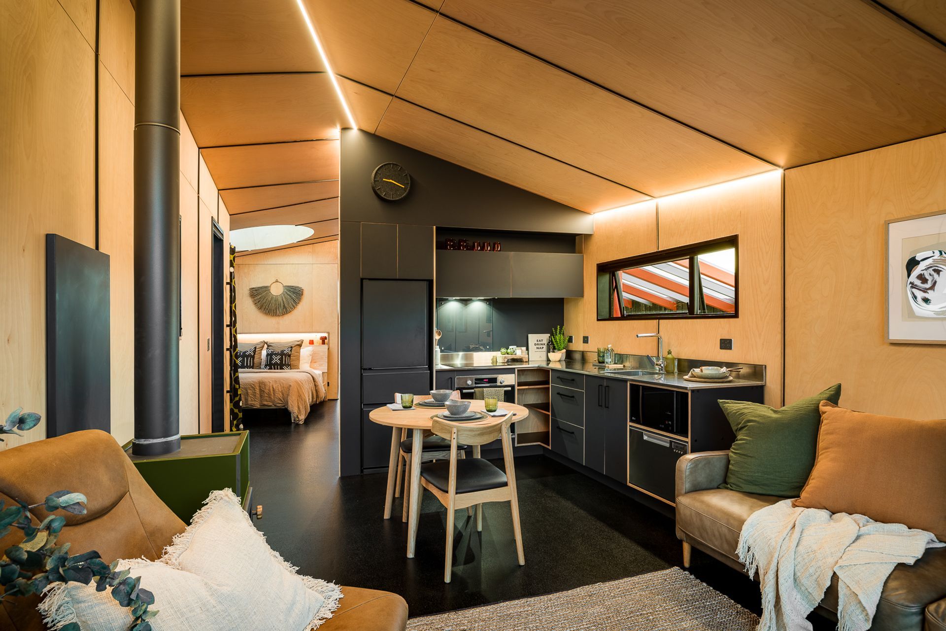 In contrast to the black larch exterior, the beech plywood interior reflects the warm, natural tones of the tussock grasses and helps extend the feeling of being nestled right in the landscape.