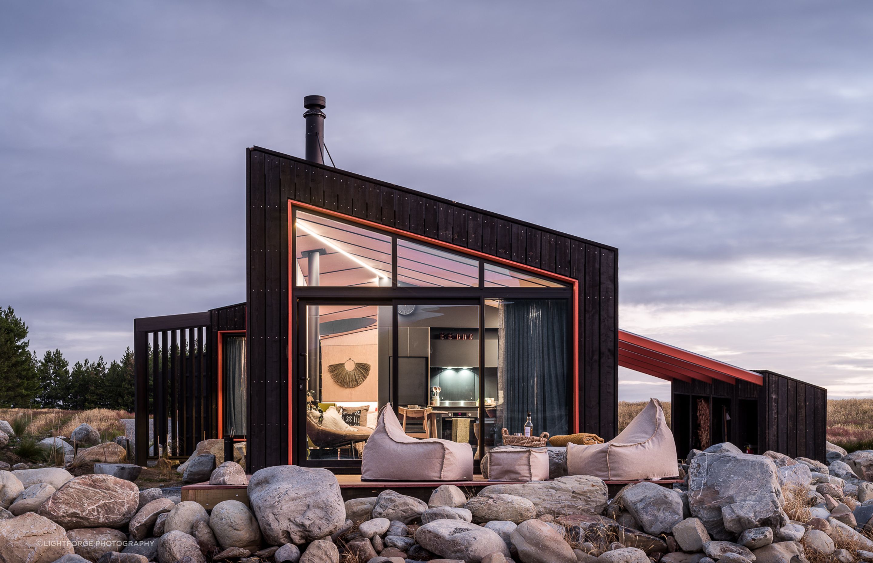A deck, built over and around the rock plinth, provides an all-important outdoor space from which to revel in the peaceful surroundings.