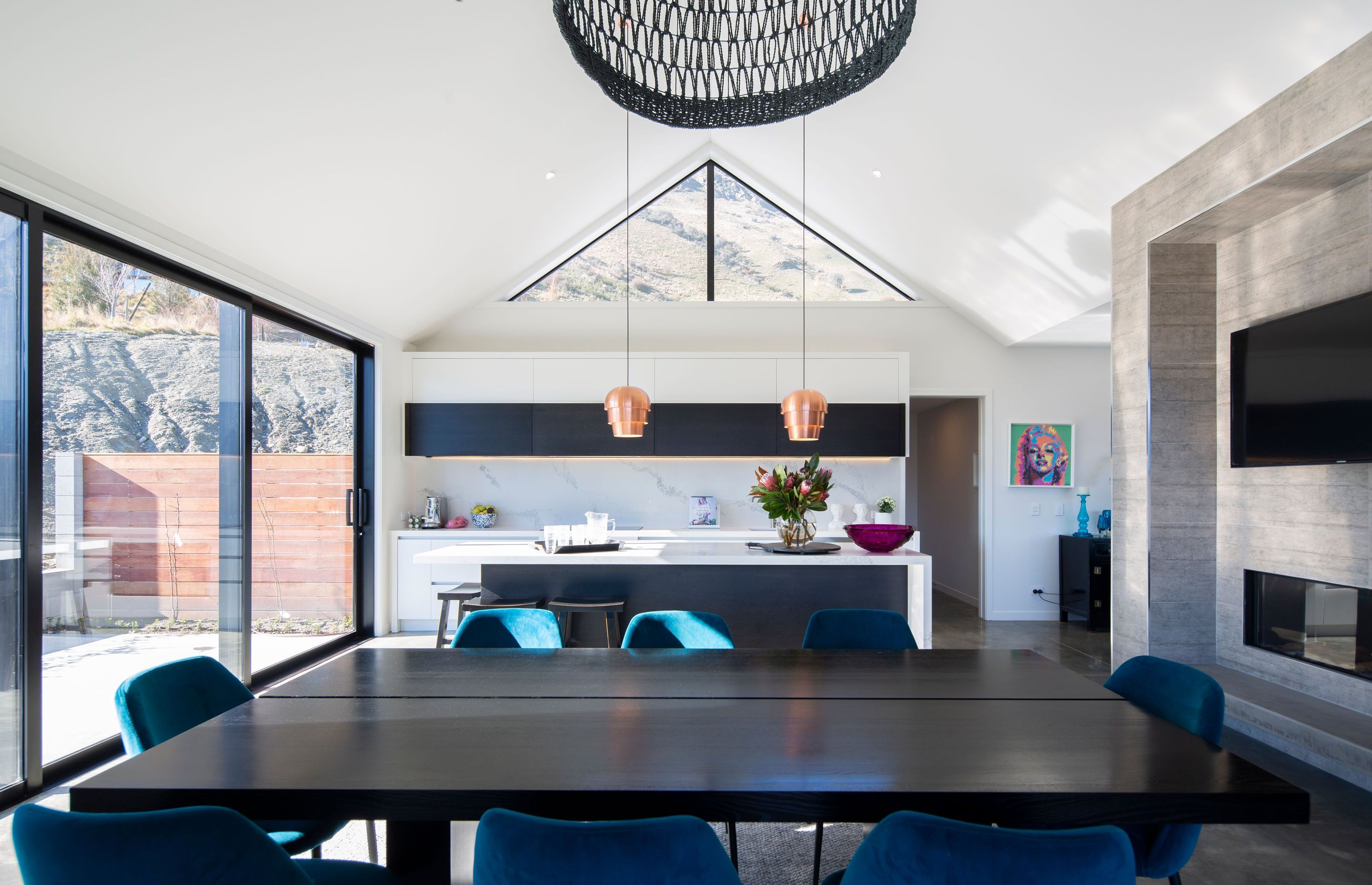 The apex above the kitchen rises to 5.4 metres and has clerestory windows to admit the view. Copper Pine Cone pendants are from BoConcept.