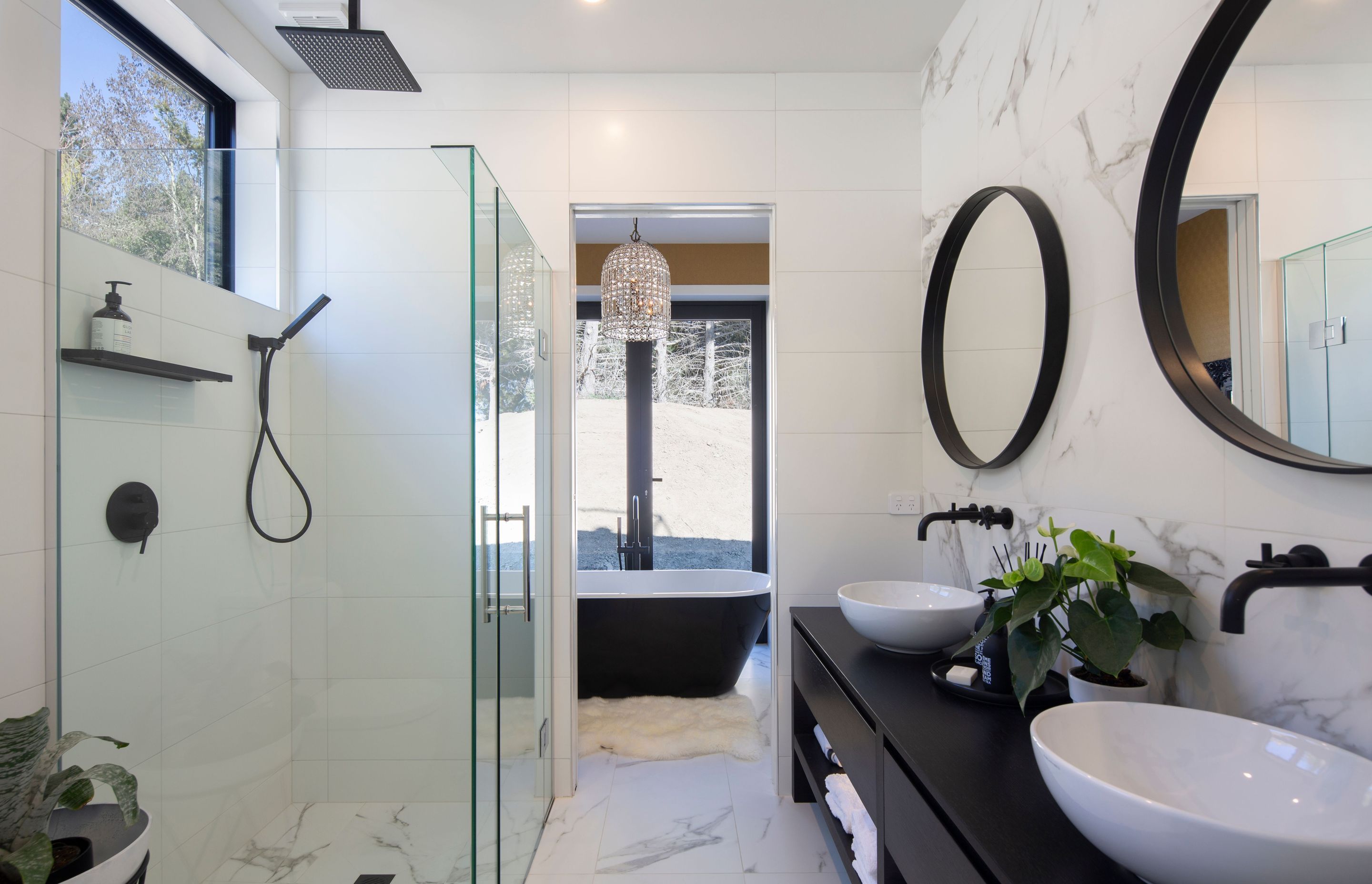 Main bathroom which follows a contemporary black and white theme with same marble floor tiling as the guest bathroom from Flooring Xtra.