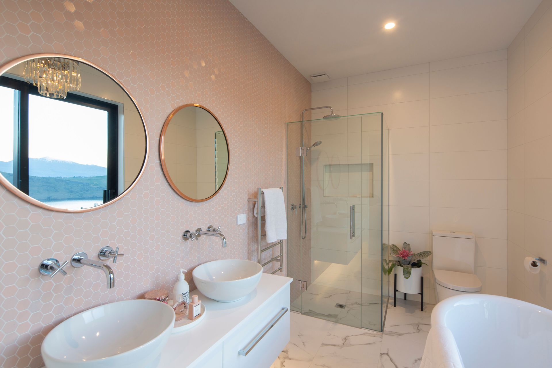 Beautifully feminine guest bathroom with blush beehive feature wall and marble floor tiles from Flooring Xtra.