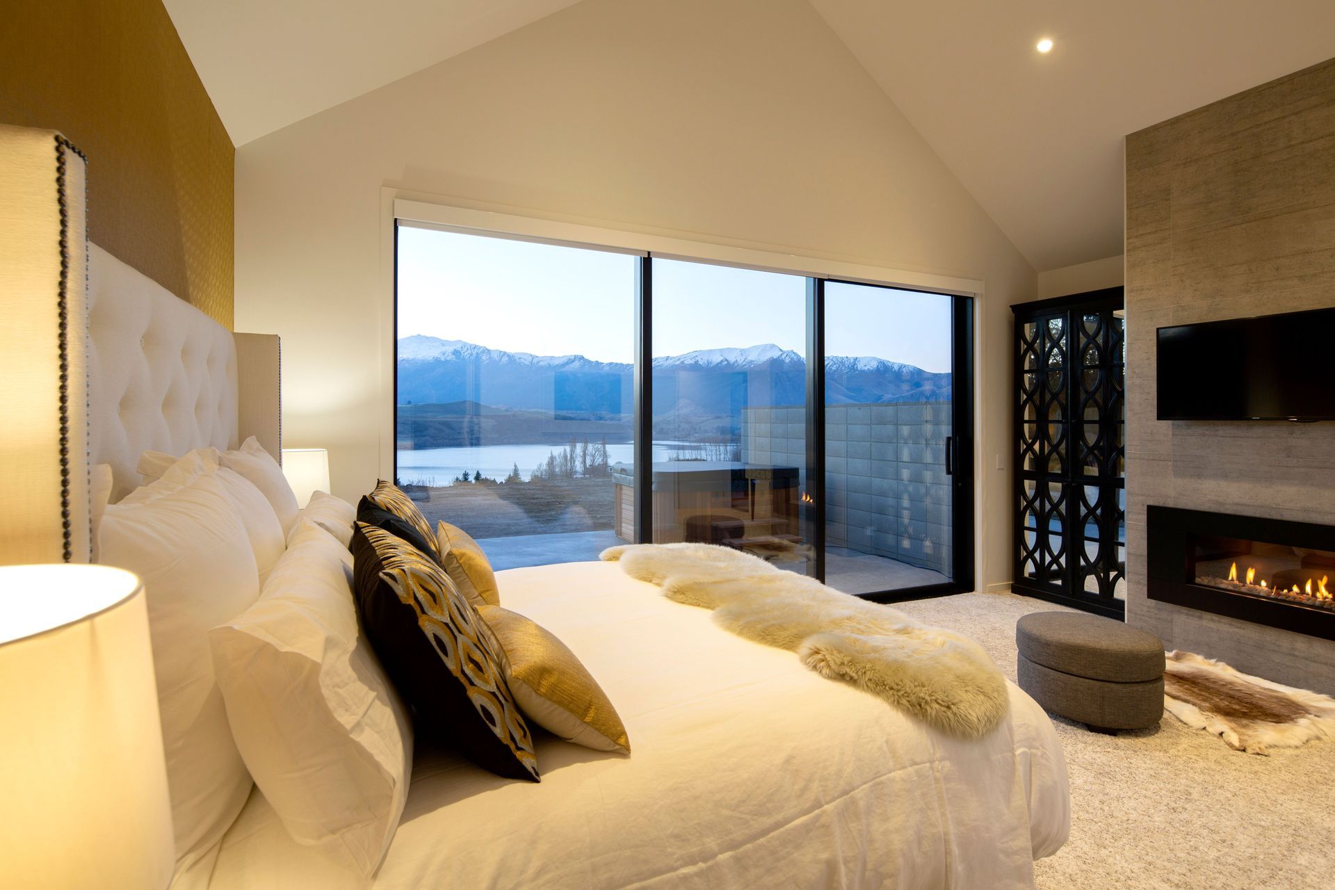 Main bedroom featuring a fireplace and decorative mirrored cupboard to reflect the view.