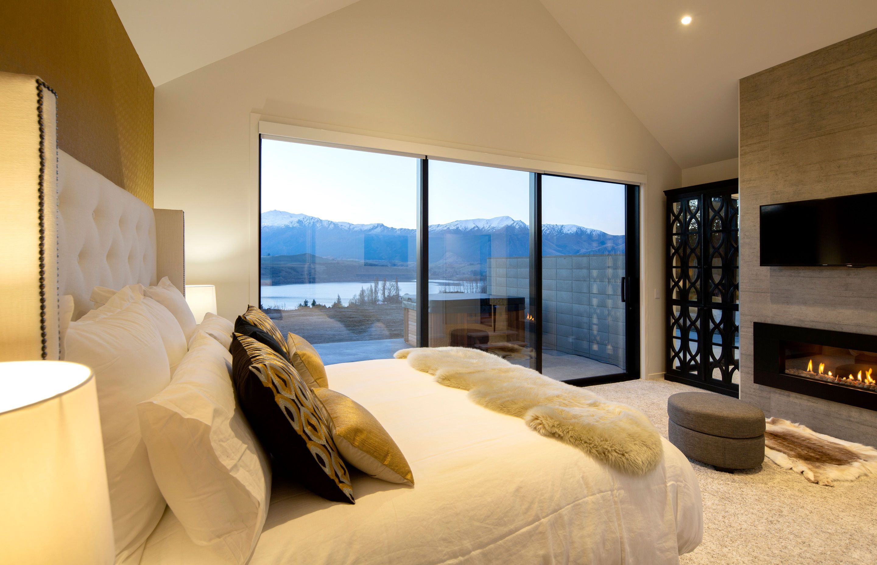 Main bedroom featuring a fireplace and decorative mirrored cupboard to reflect the view.