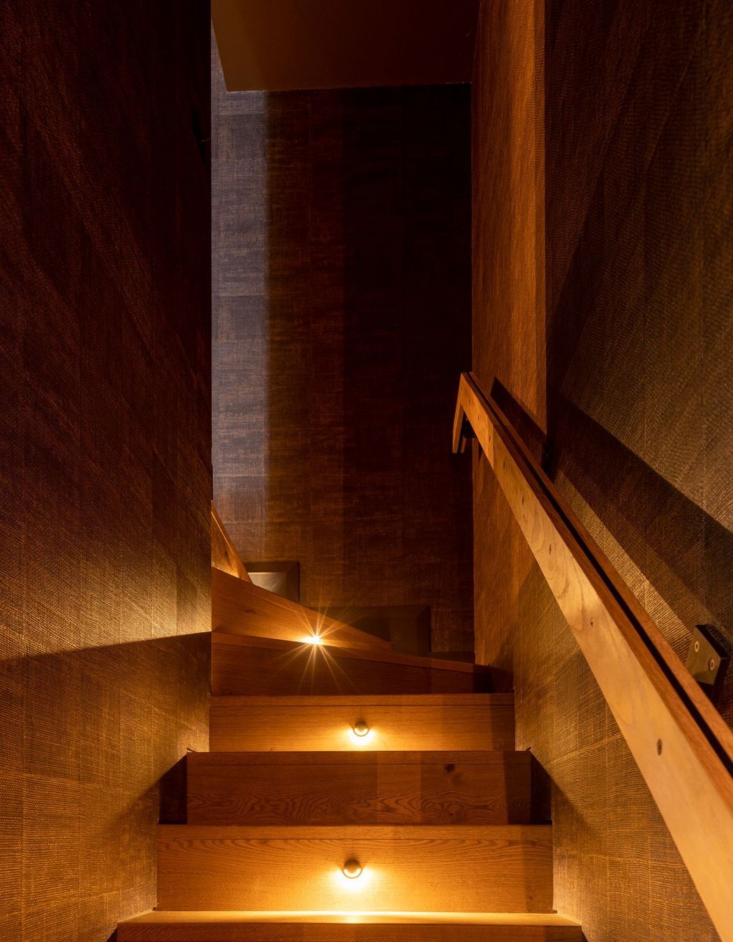 “It’s this little sense of discovery going up the stairs, almost like a hidden piece of the house. There’s dramatic step lighting with a very textured wall covering that then goes up into the media room.”