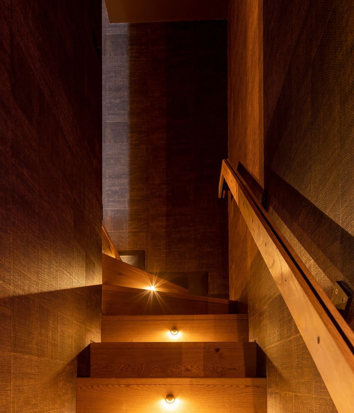 “It’s this little sense of discovery going up the stairs, almost like a hidden piece of the house. There’s dramatic step lighting with a very textured wall covering that then goes up into the media room.”