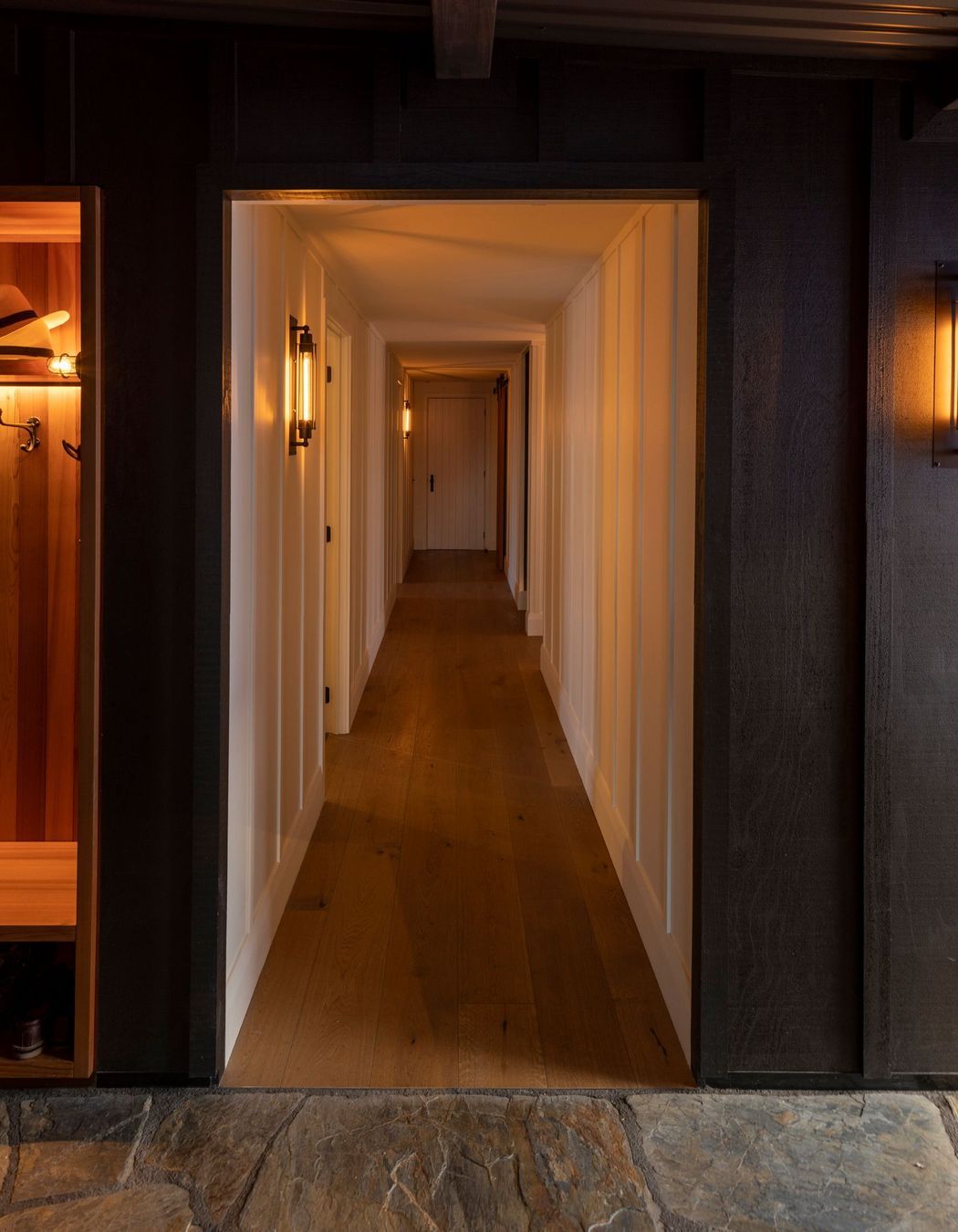 The exterior cladding and corrugated iron roof of the lean-to entrance that joins the two building forms. Clutha stone is on the floor.