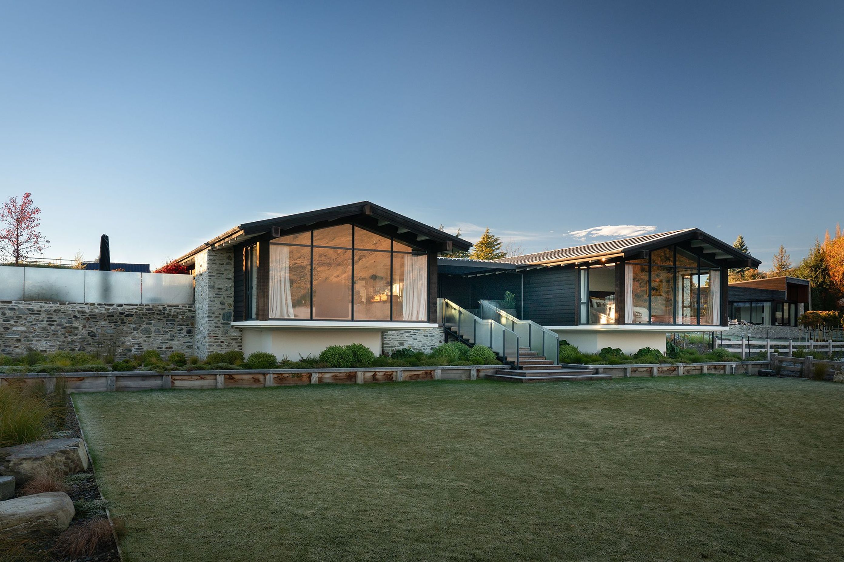 Situated on an enviable lakeside section, this house sits fat and low-slung, with expansive floor-to-ceiling glazing taking full advantage of the vista.