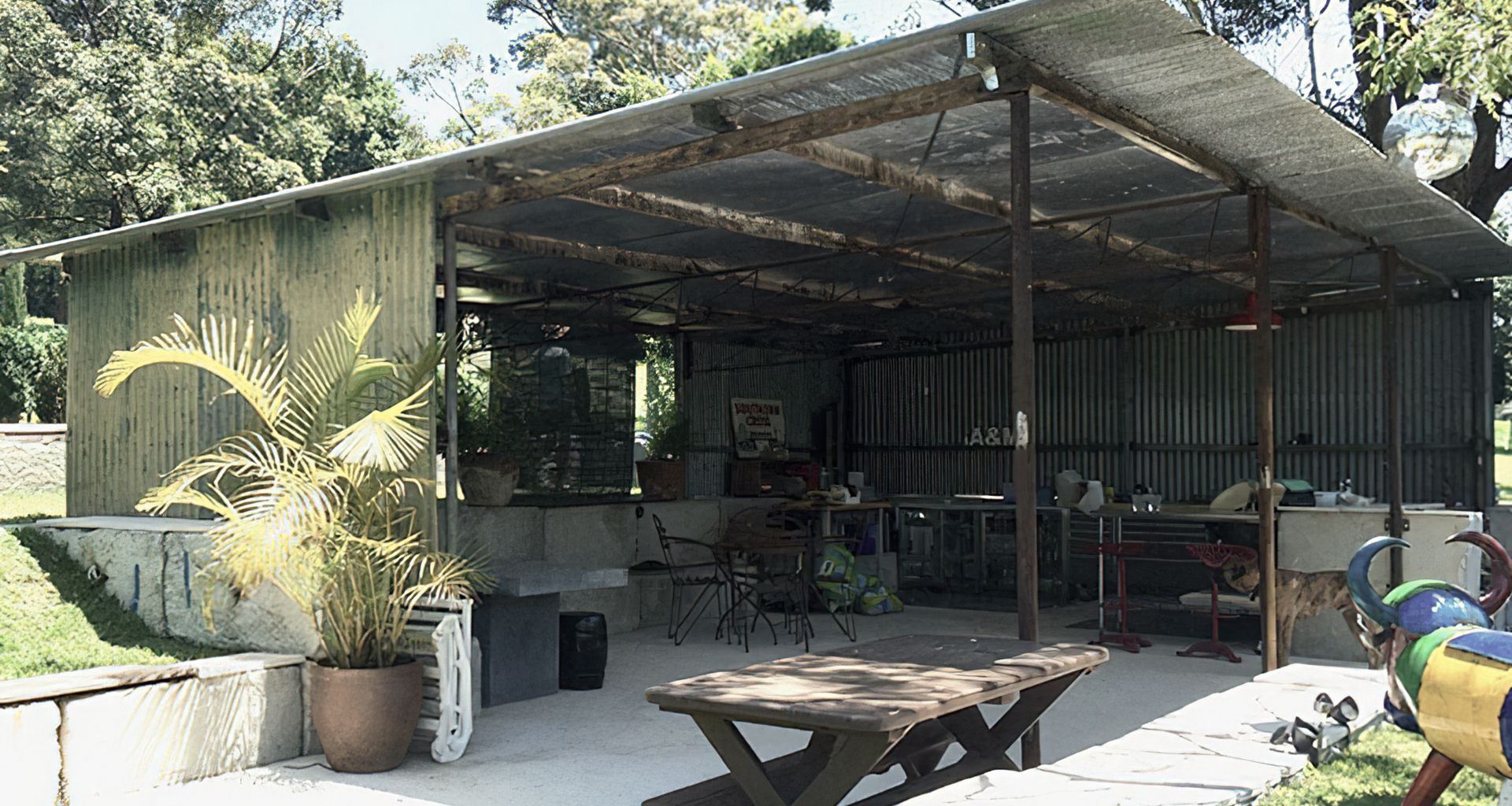 Lakeside entertainment house made from relocated patinated farm shed, mounted on concrete waste blocks