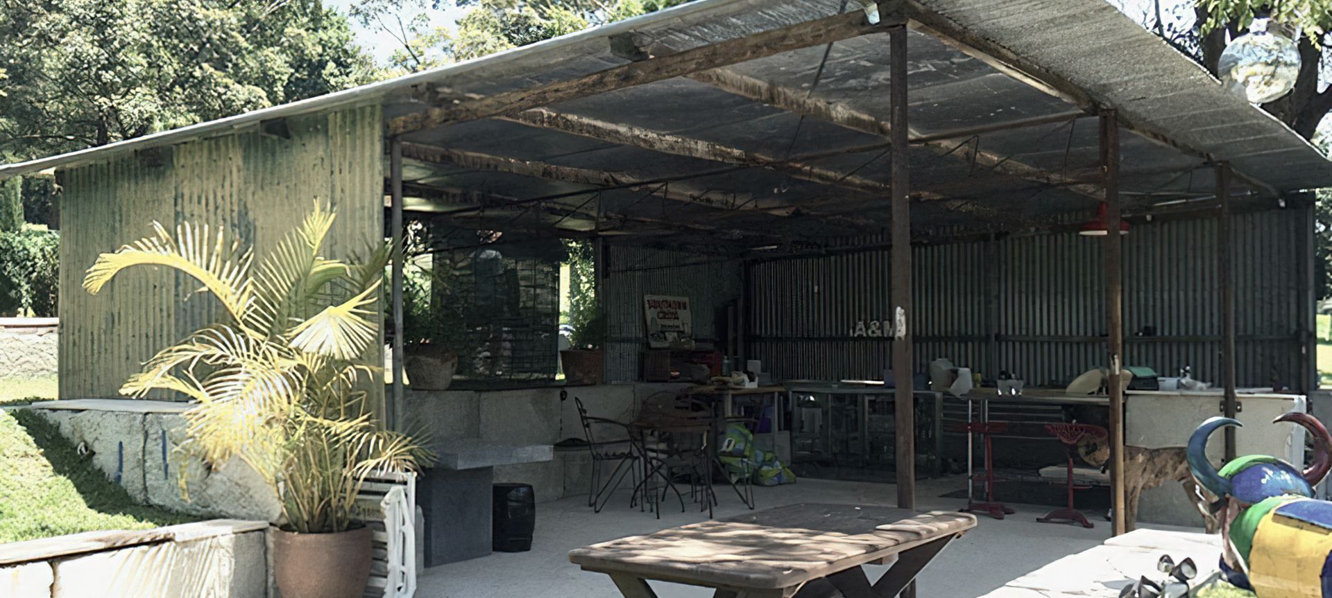 Lakeside entertainment house made from relocated patinated farm shed, mounted on concrete waste blocks