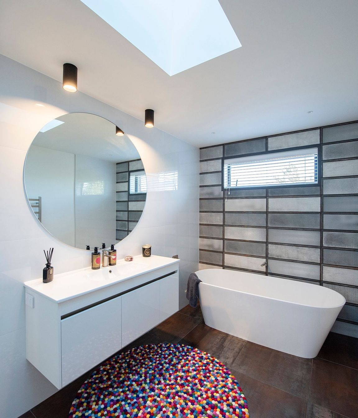 A Vertralla II freestanding bath takes centrestage in this bathroom where Corten A floor tiles pick up on the weathered kitchen splashback and Absolute Bianco wall tiles have the look of concrete.