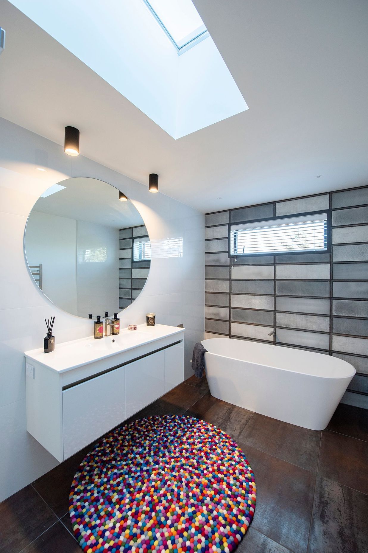 A Vertralla II freestanding bath takes centrestage in this bathroom where Corten A floor tiles pick up on the weathered kitchen splashback and Absolute Bianco wall tiles have the look of concrete.