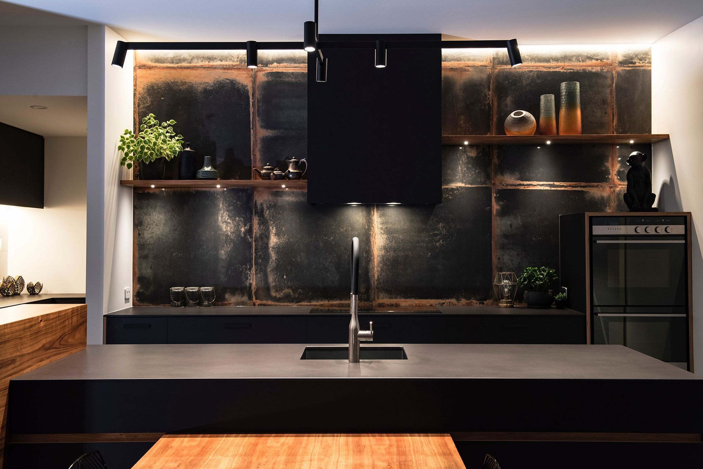 LookBack Black Tiles with a rusted patina are a talking point in the kitchen which has black cabinetry and a ply edge detail.