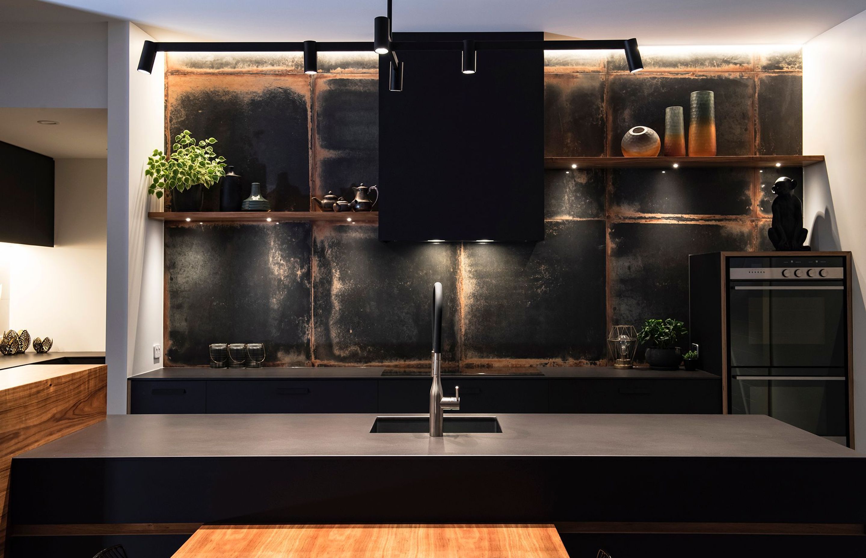 LookBack Black Tiles with a rusted patina are a talking point in the kitchen which has black cabinetry and a ply edge detail.