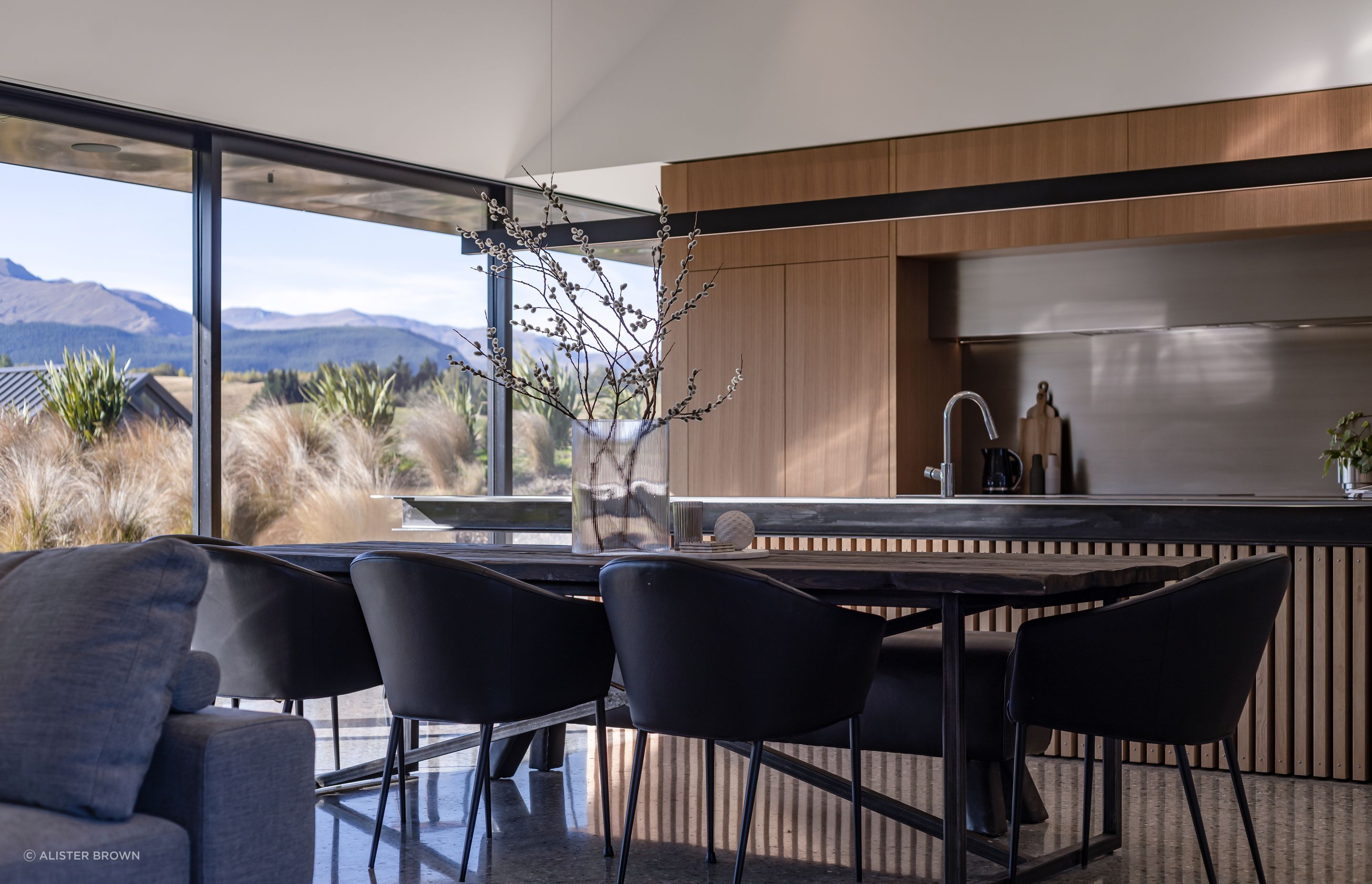 Oak cabinetry and stainless steel feature in the kitchen, with a cantilevered beam light over the island bench.