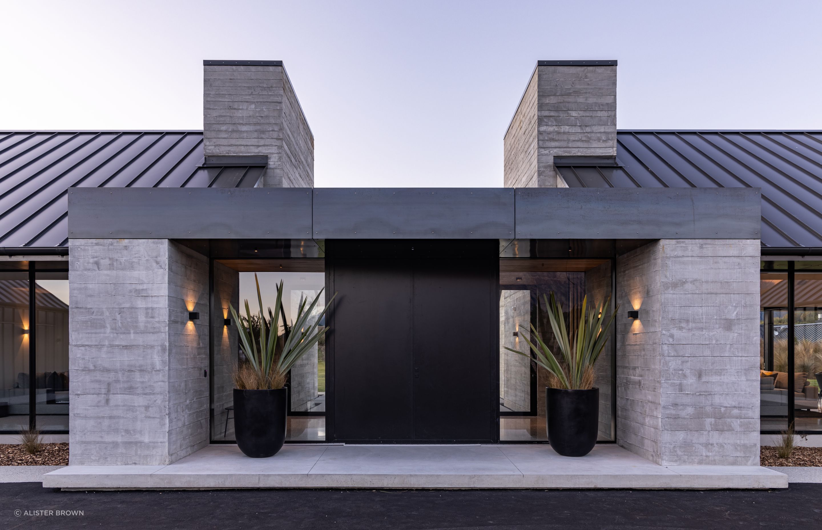 The entrance is centred, a large pivot door welcoming visitors to the home.