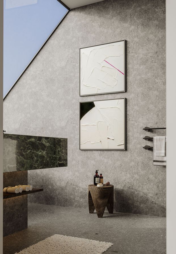 A refined contemporary bathroom with textured grey concrete-look walls and matching floor, a dark green marble feature panel, frameless mirror, wall-mounted towel rack, and sculptural timber stool with toiletries. Abstract artwork adds subtle colour, while a skylight brings in natural light. The space has a luxurious, moody and minimalist character.