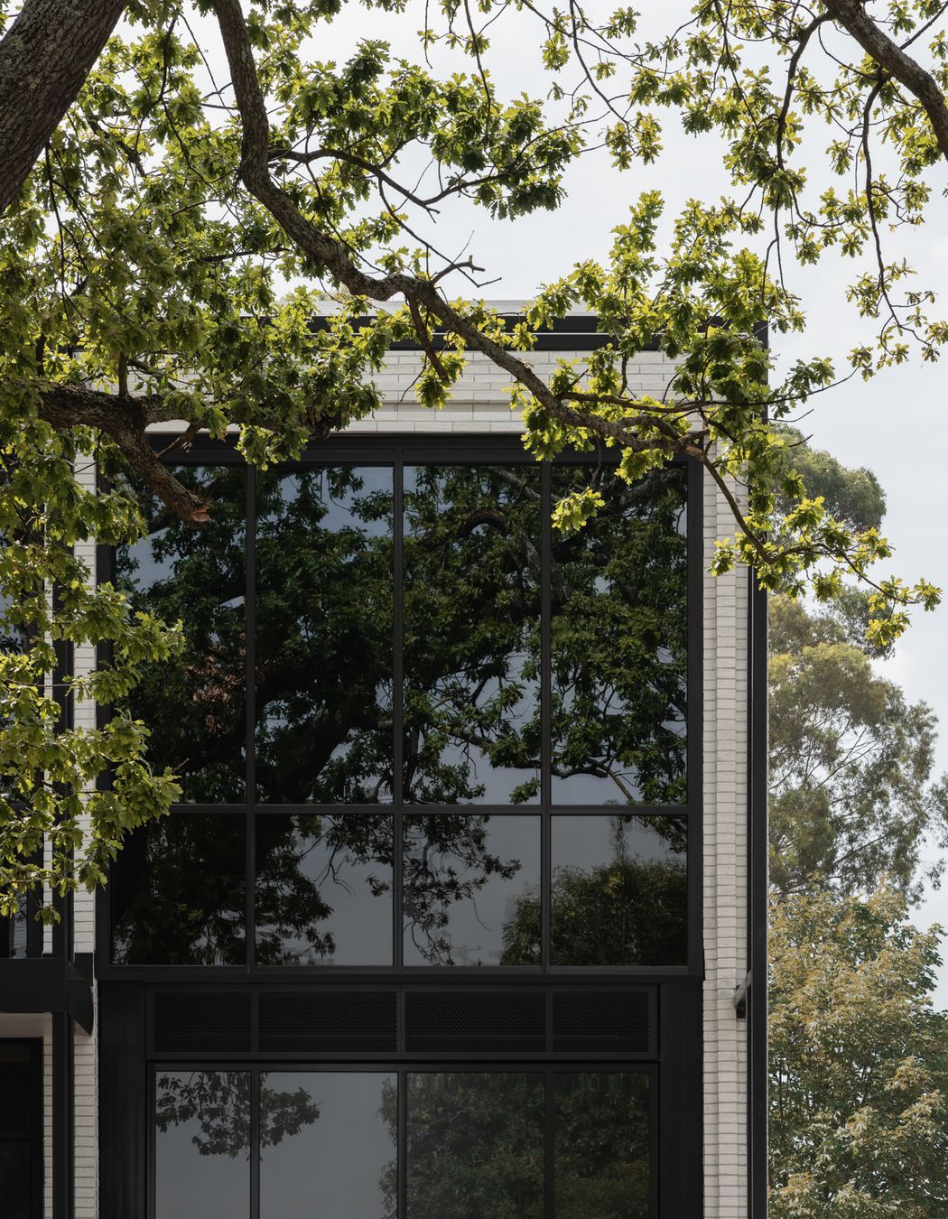 Brick Inlay delivers a finely tuned facade, featuring Mattoncino Grande Bianco brick tiles on the residential side