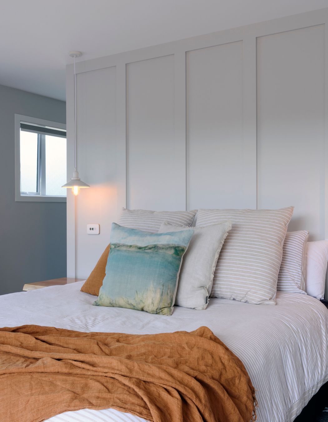 Walls were panelled for a classic effect and owner chose French look striped linen and a throw in a rich colour, both from Adairs.