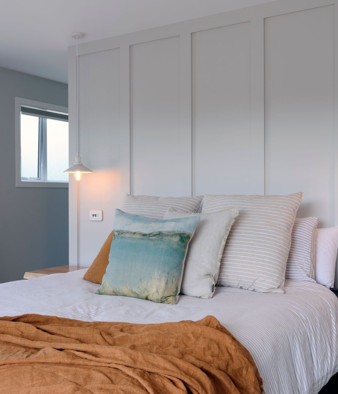 Walls were panelled for a classic effect and owner chose French look striped linen and a throw in a rich colour, both from Adairs.