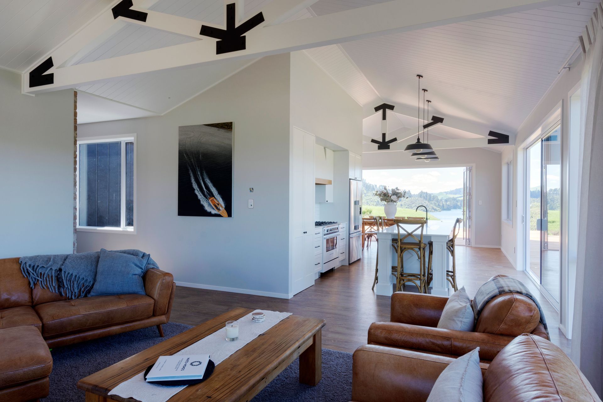 The warehouse appeal of exposed trusses in main living area is softened by white walls and ceilings