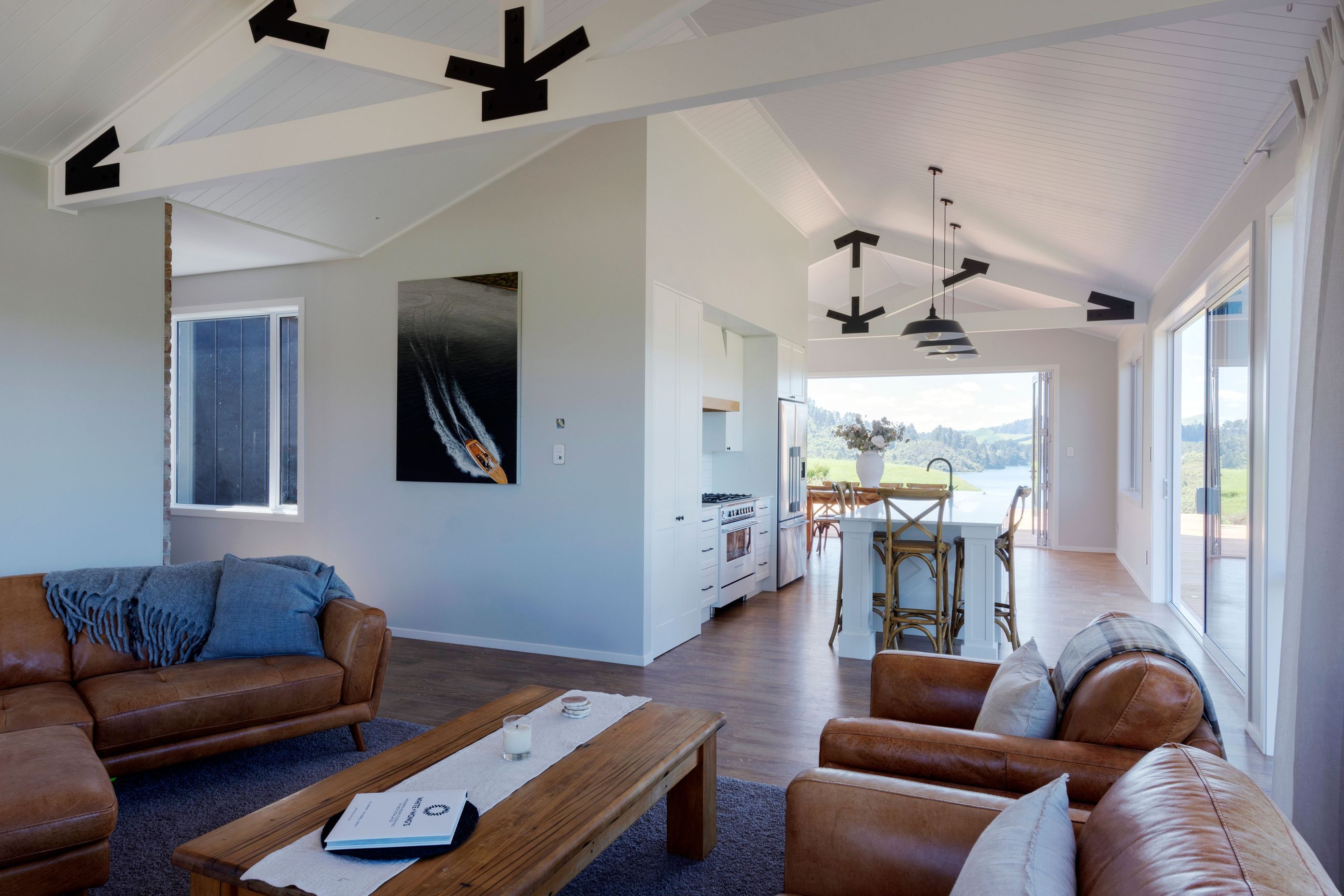 The warehouse appeal of exposed trusses in main living area is softened by white walls and ceilings