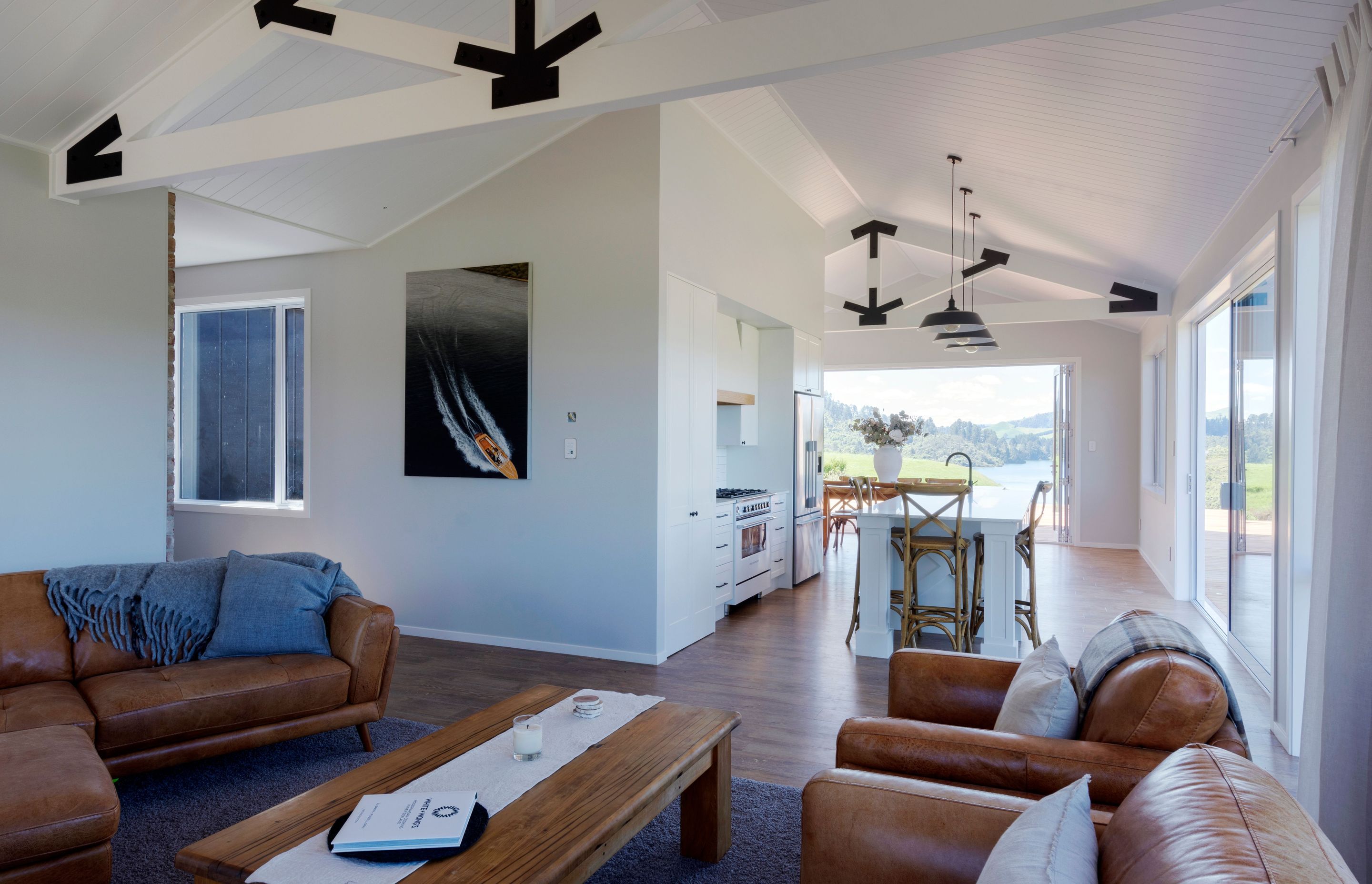 The warehouse appeal of exposed trusses in main living area is softened by white walls and ceilings