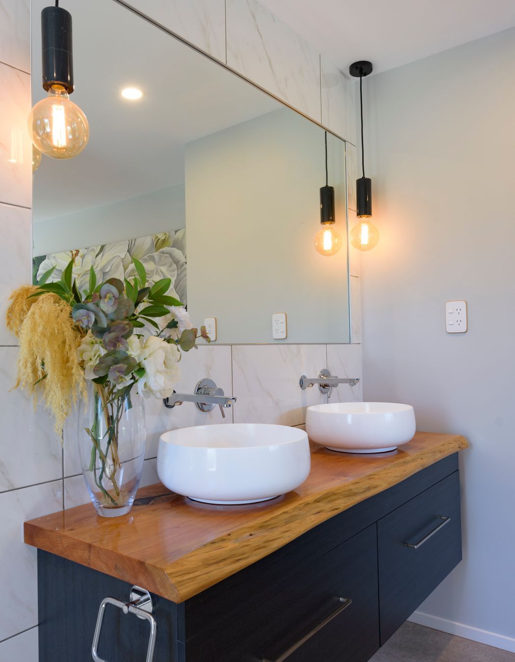 Vanity top has been made from a macrocarpa slab by homeowner's father. The twin vessels are Athena Sirca Bowls and Mr Marble Bare Bulb pendants from Mr Ralph illuminate the room.