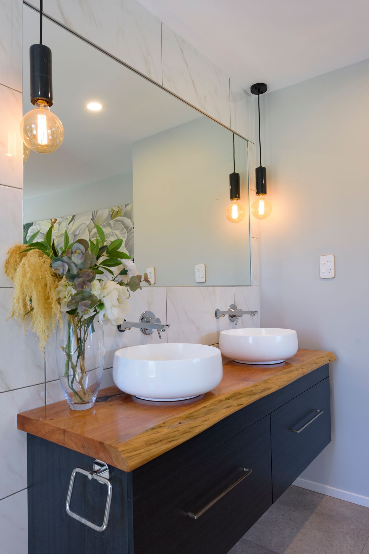 Vanity top has been made from a macrocarpa slab by homeowner's father. The twin vessels are Athena Sirca Bowls and Mr Marble Bare Bulb pendants from Mr Ralph illuminate the room.