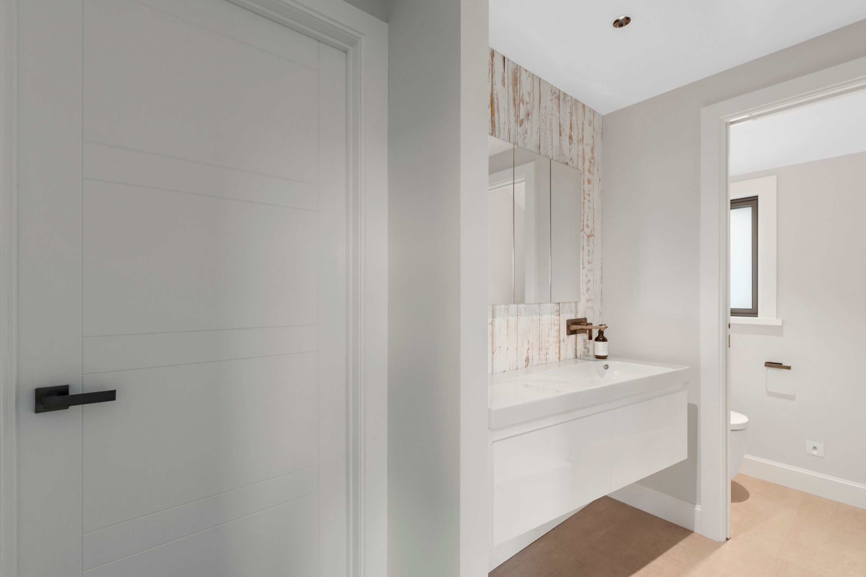 The bathrooms have been given a crisp white palette with gunmetal accents to create a modern beachy feel.